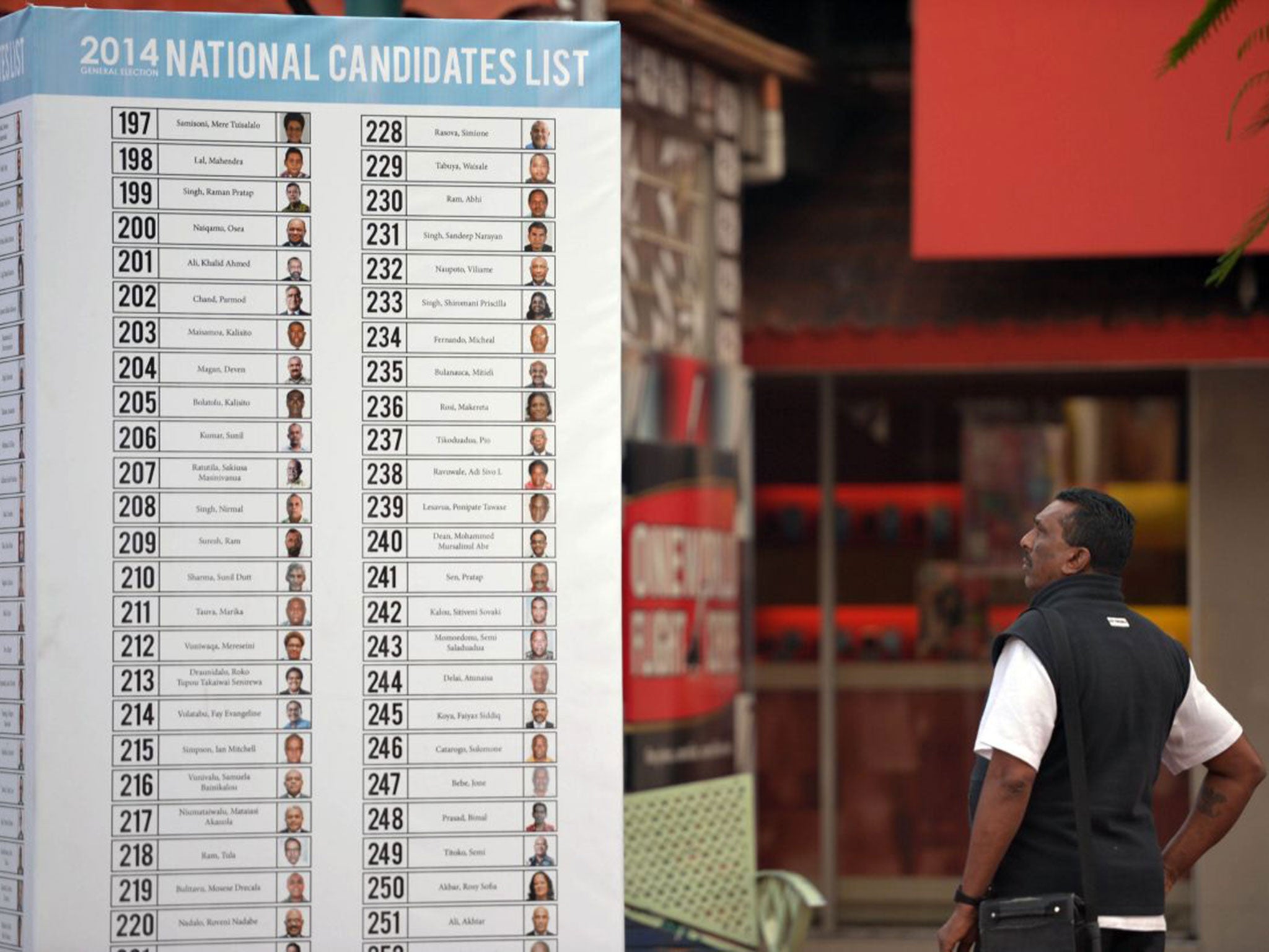 A man looks at the list of candidates for the election in Fiji