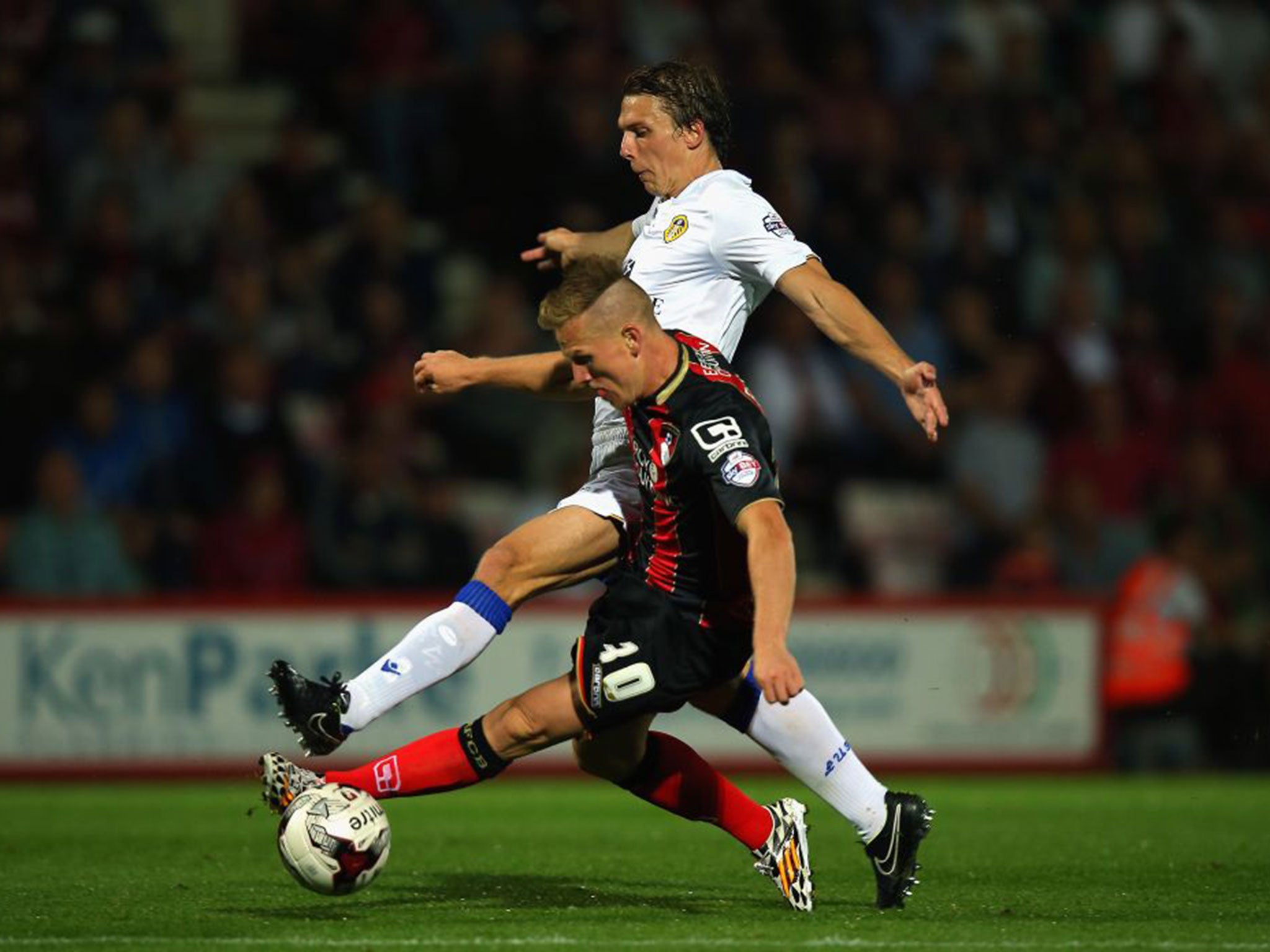 Matt Ritchie of Bournemouth, front, and Stephen Warnock of Leeds United challenge for the ball at the Goldsands Stadium on Tuesday night
