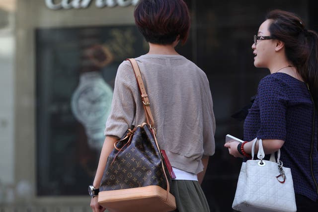Chinese women walk past the Cartier store on June 11, 2012 in Beijing, China.