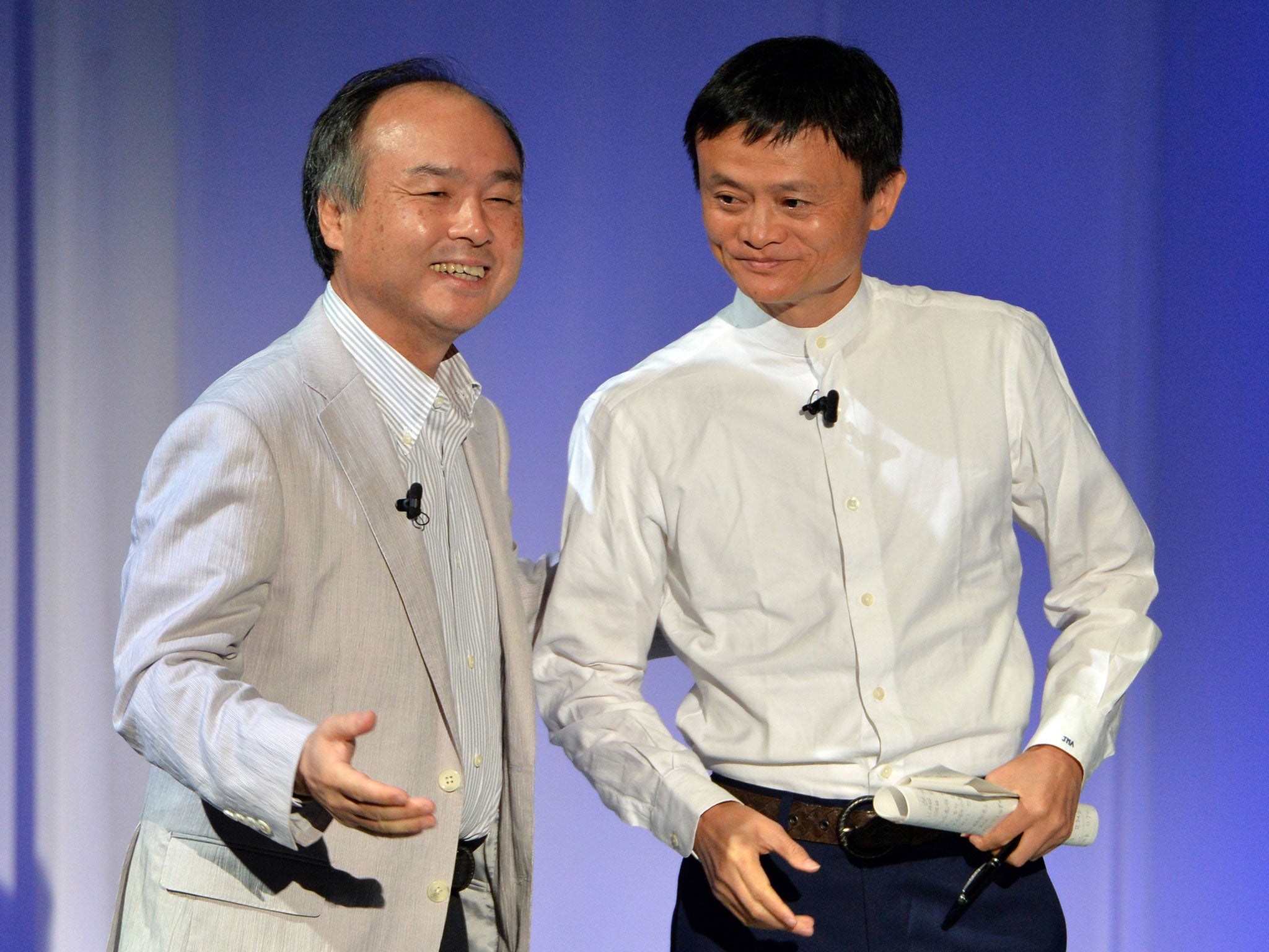 Softbank president Masayoshi Son (L) introduces Alibaba Group chairman Jack Ma during the Softbank World 2014 annual forum in Tokyo on July 15, 2014