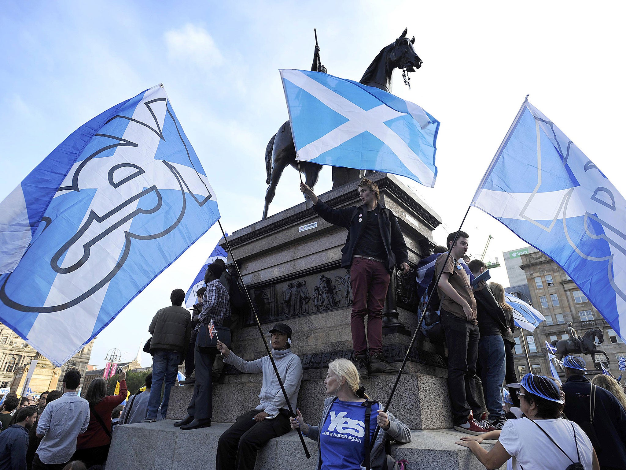 Pro-independence supporters wave Scottish flags in Glasgow's George Square, in Scotland, on September 17, 2014.