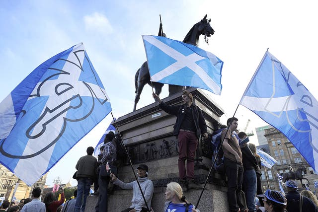 Pro-independence supporters wave Scottish flags in Glasgow's George Square, in Scotland, on September 17, 2014.
