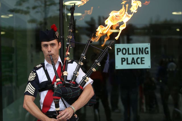 Ryan Randall plays the bagpipes outside a polling station in Edinburgh, Scotland