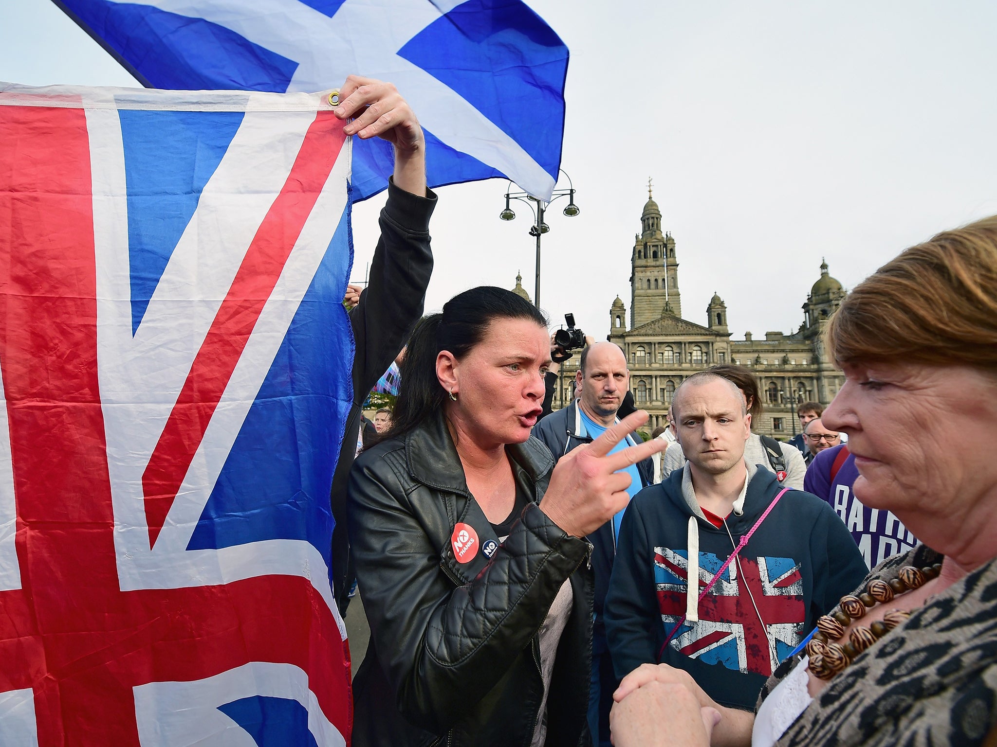 A yes supporter talks with a man and a woman with a Union flag in George Square, just a few hours before polling stations will close in the Scottish independence referendum