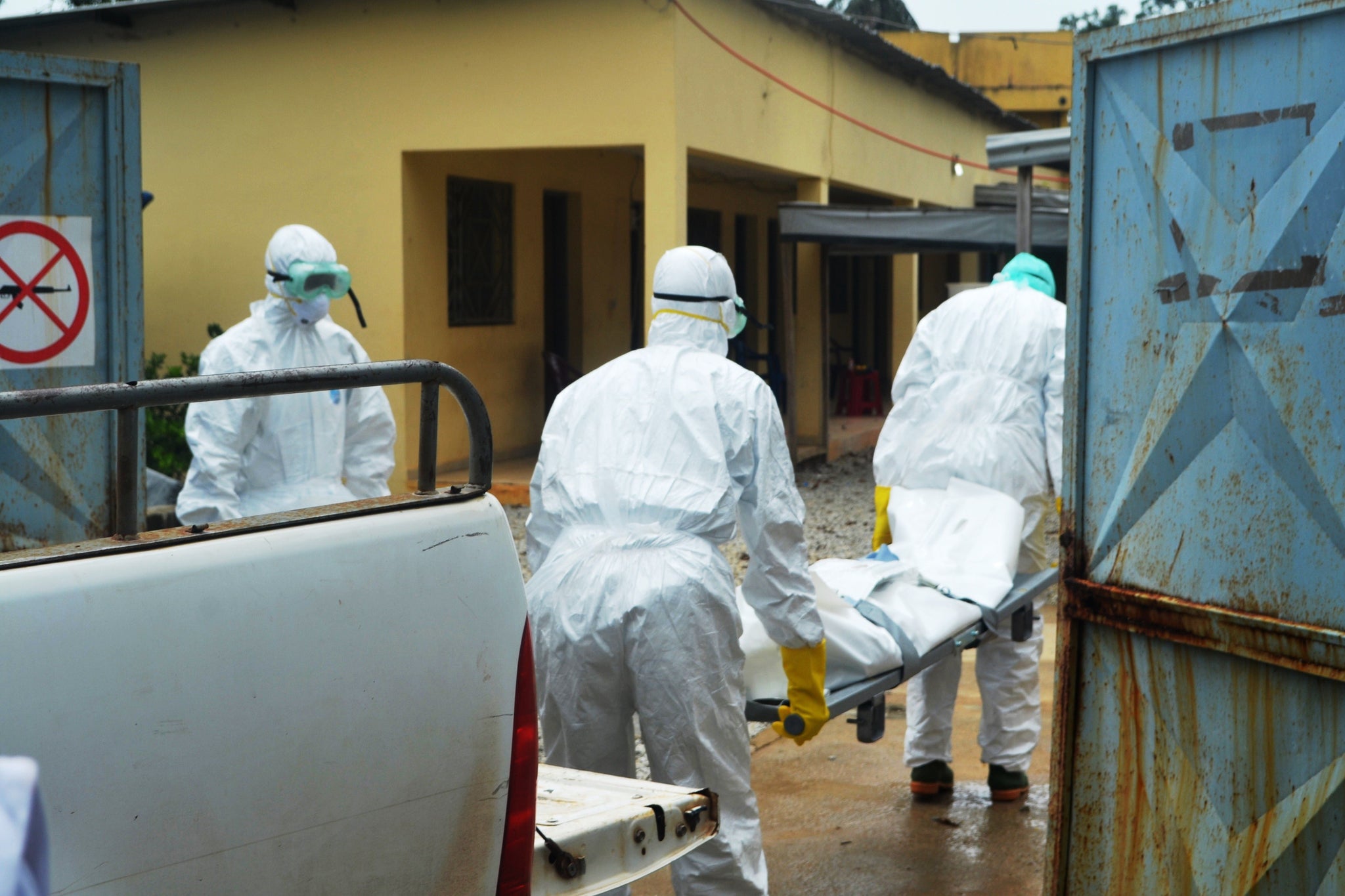 Guinea's Red Cross health workers wearing protective suits carry the body of a victim of Ebola virus at the NGO Medecin sans frontieres Ebola treatement centre near the hospital Donka in Conakry on September 14, 2014.