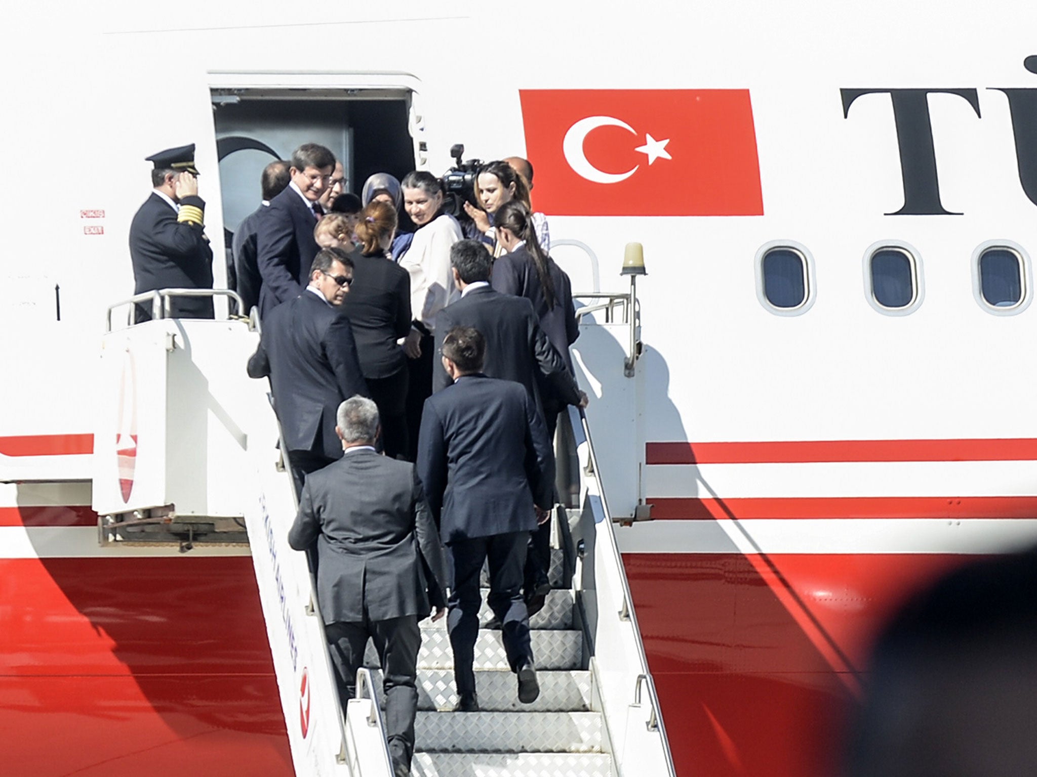 Turkish Prime Minister Ahmet Davutoglu (L, top of the gangway) gets into his plane with hostages on September 20