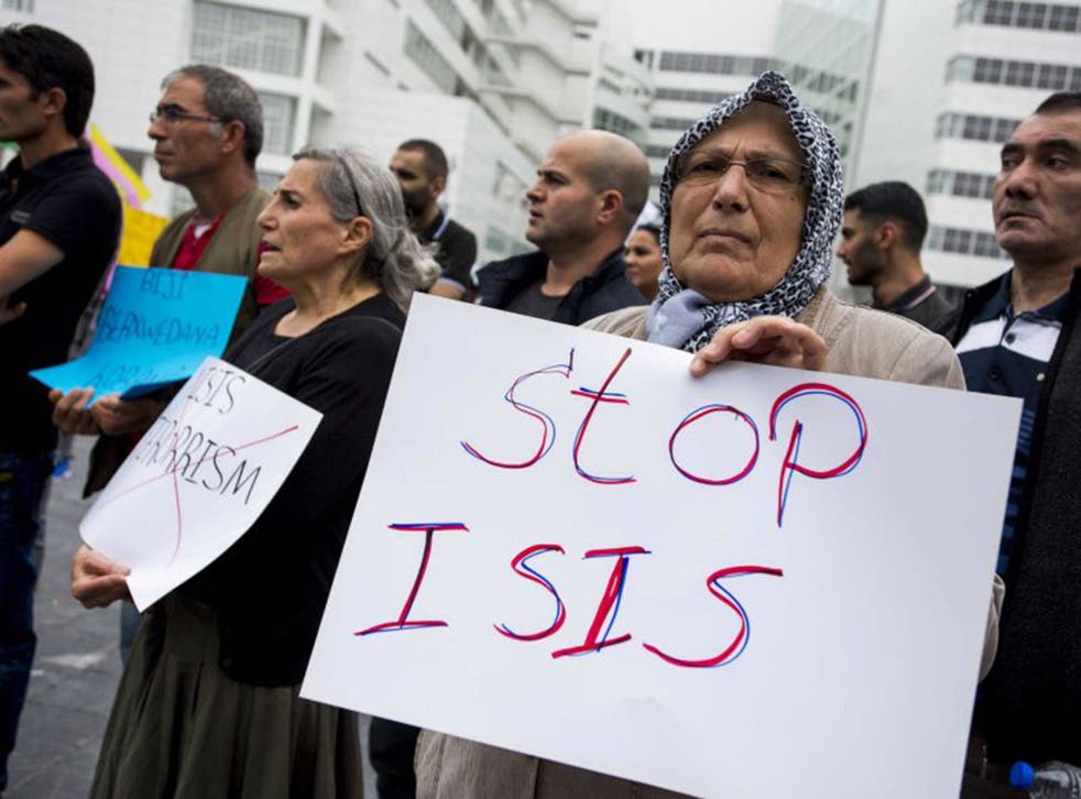 A supporter of the Kurdistan Workers' Association holds a placard during a demonstration against Islamic State (IS) in front  The Hague