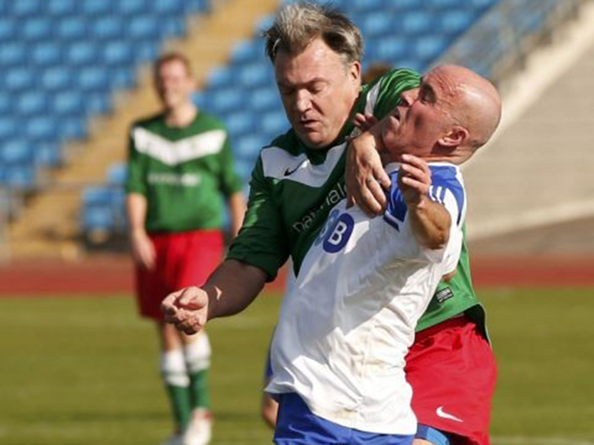 Britain's shadow chancellor Ed Balls (L) challenges reporter Rob Merrick for the ball during the Labour Party versus the media soccer match,