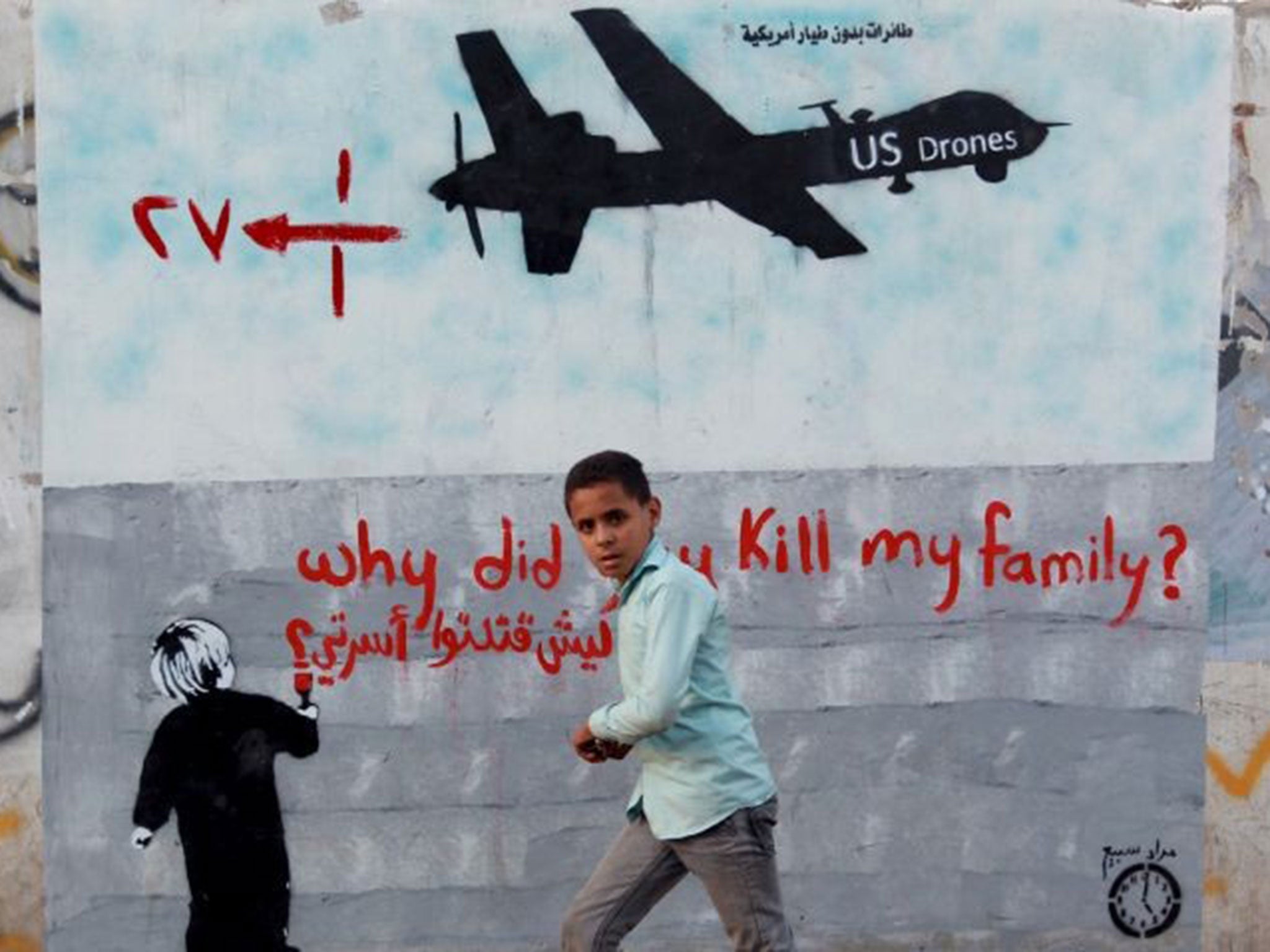 Air shot: a Yemeni boy walks past a mural in Sanaa that is critical of strikes by US drones