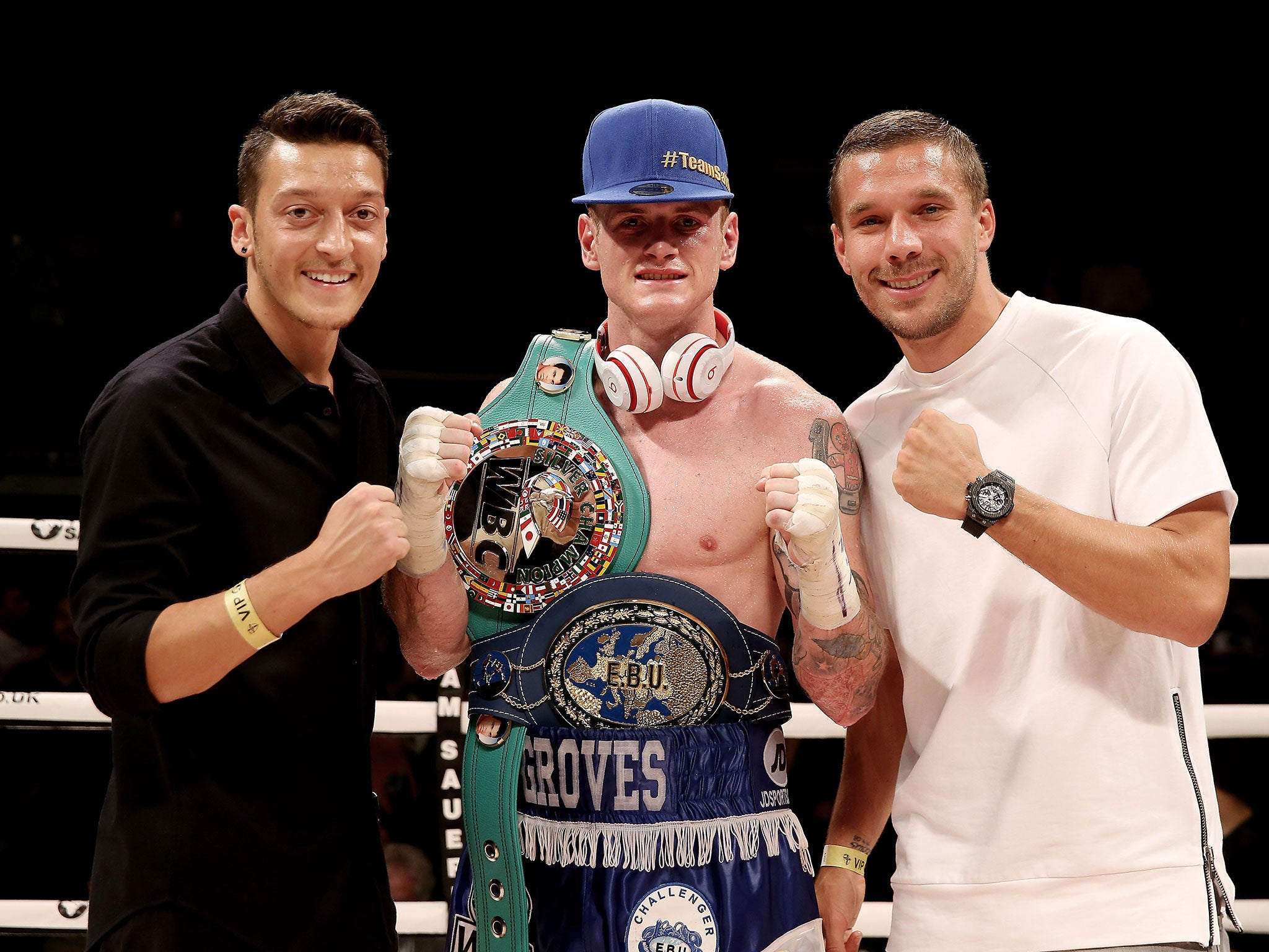 Groves poses with Arsenal's German players Mesut Ozil (left) and Lukas Podolski after his win