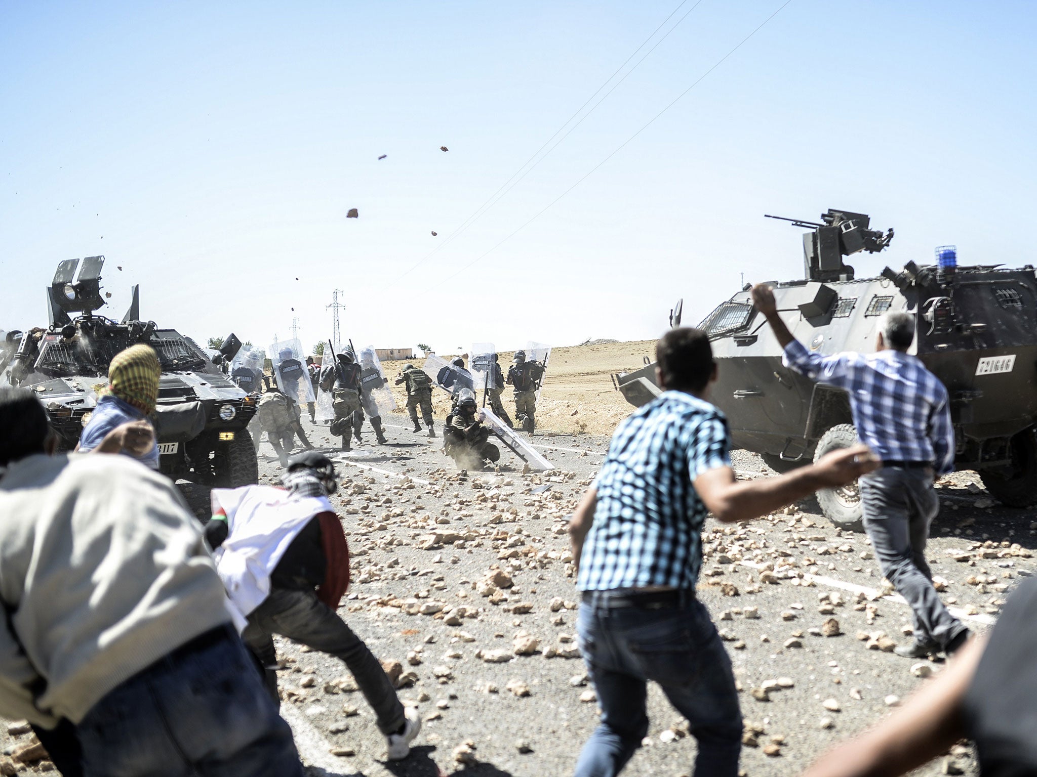 Kurdish refugees clash with Turkish soldiers near the Syrian border after Ankara temporarily closed the Suruc crossing