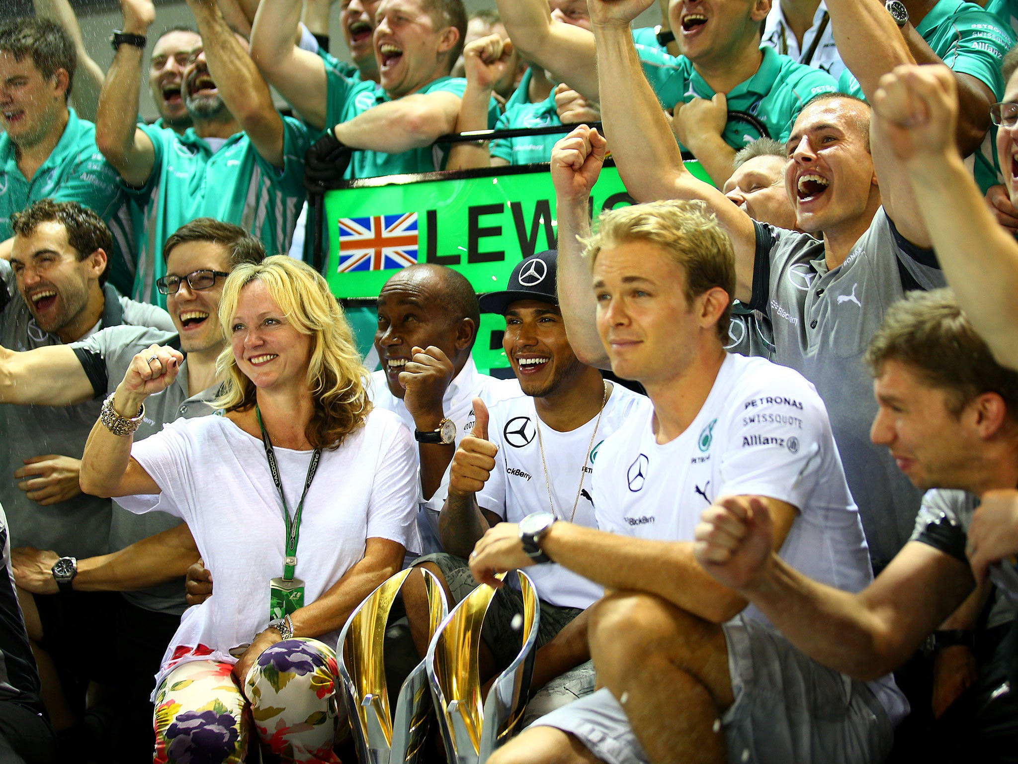 The Mercedes team celebrate Lewis Hamilton's Singapore victory as a modest Nico Rosberg looks on