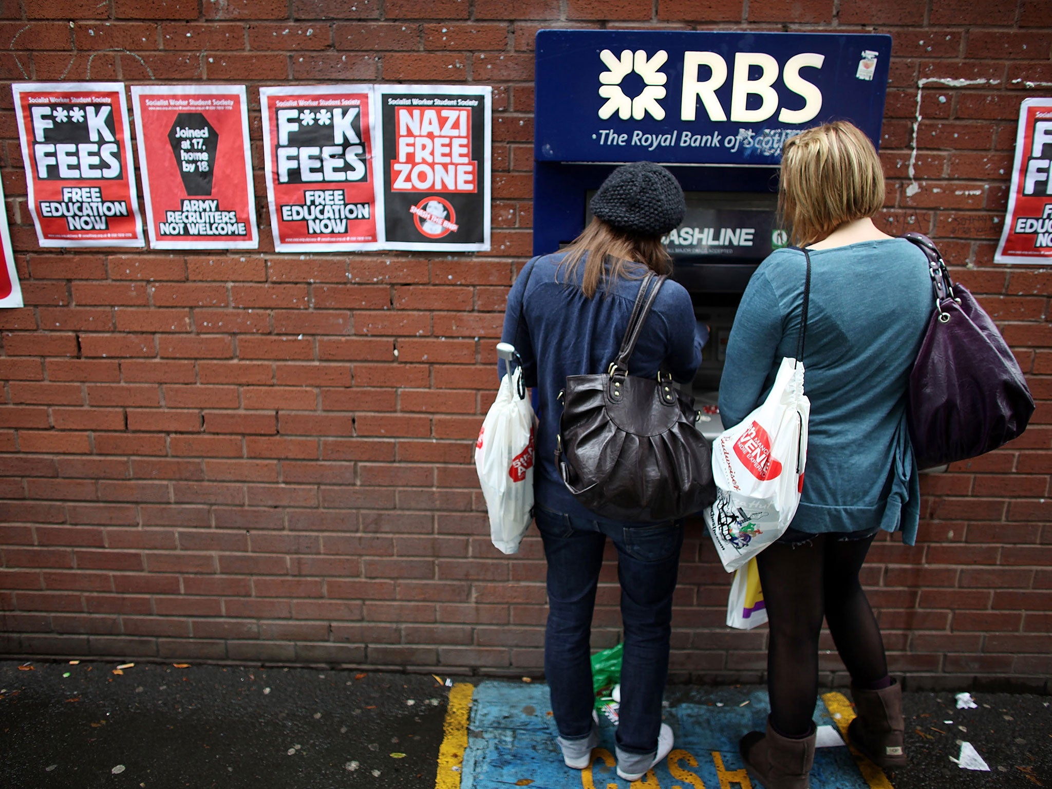 Students arriving for Manchester University's freshers week queue up at a cash machine to draw money in Manchester, England.