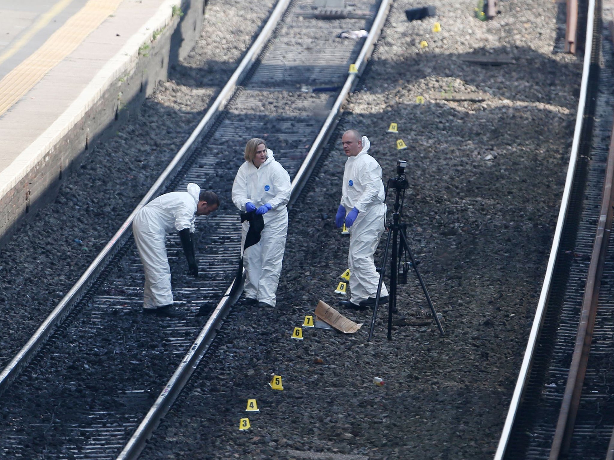 Forensic officers work on the tracks at Slough train station after a woman and a child died after being struck by a train at the station