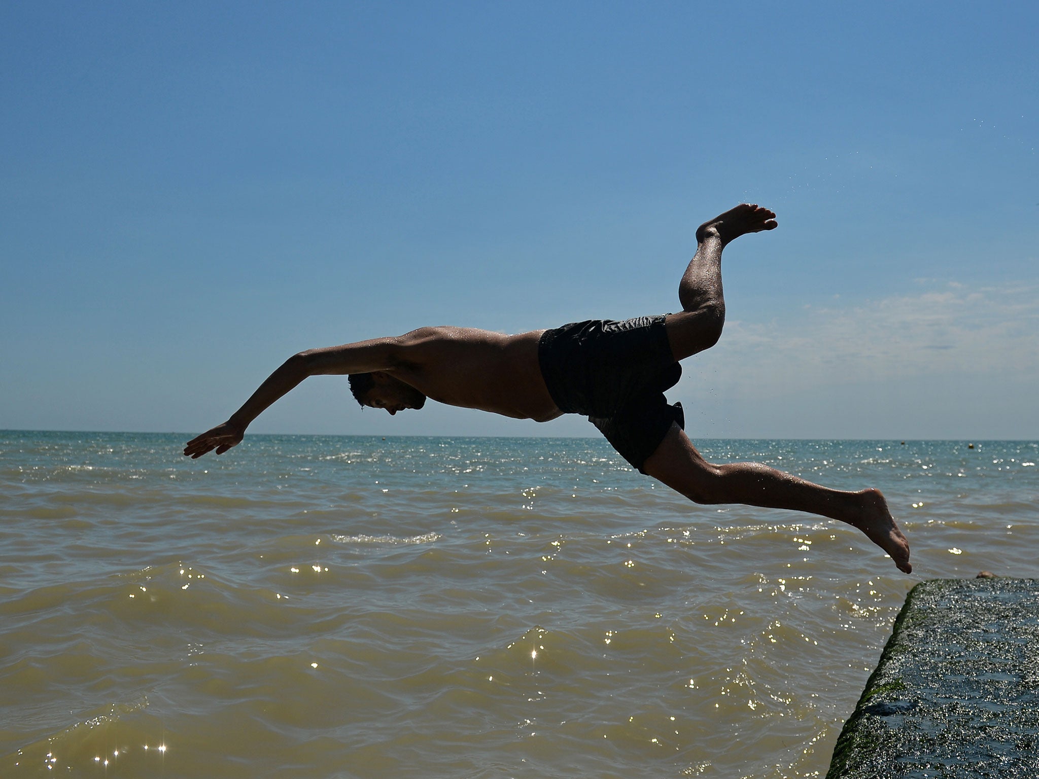 A man dives into the sea in Brighton, on the south coast during hot weather in September