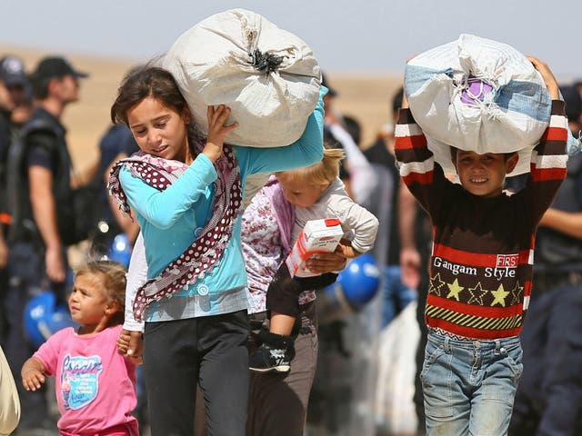 Syrian Kurdish children flee clashes between Isis and Syrian Kurd fighters in Kobane