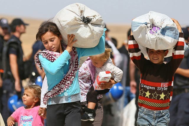 Syrian Kurdish children flee clashes between Isis and Syrian Kurd fighters in Kobane