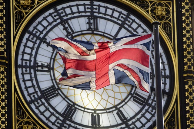 The Union flag is seen flapping in the wind in front of one of the faces of the Great Clock atop the landmark Elizabeth Tower that houses Big Ben at the Houses of Parliament   