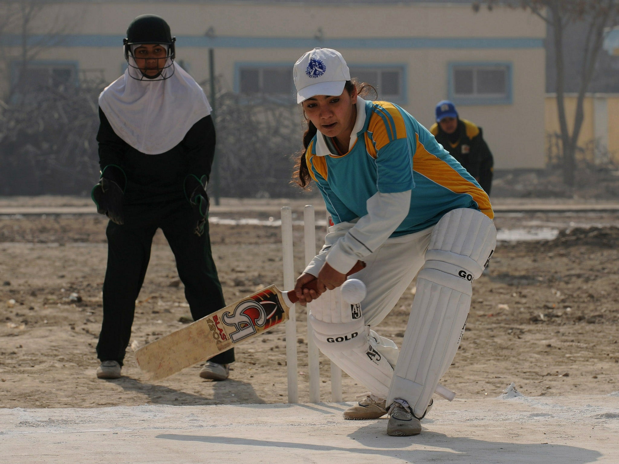 Afghan girls play cricket on the school grounds in Kabul