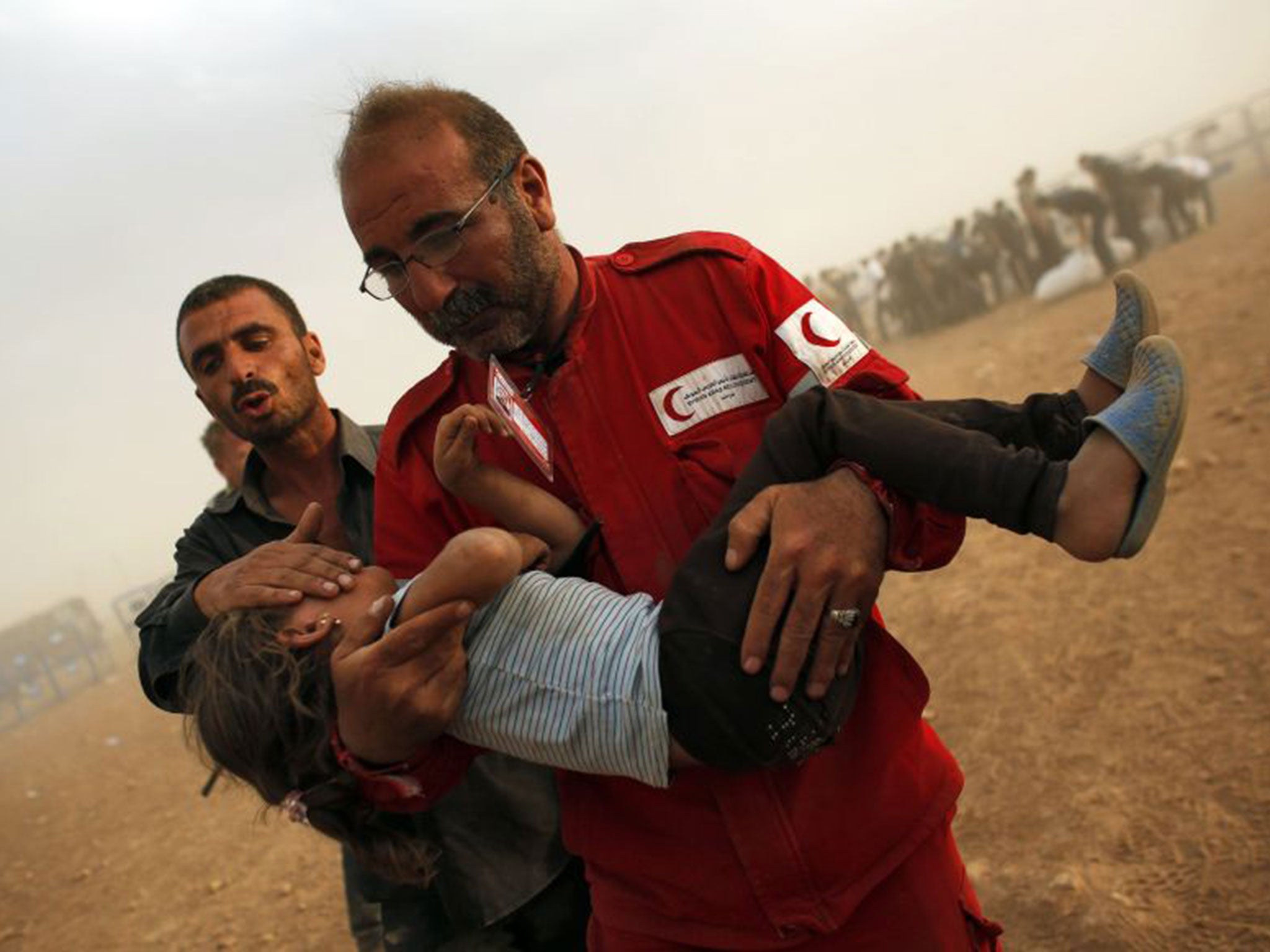 A Syrian Kurdish girl is rescued by a Red Crescent worker