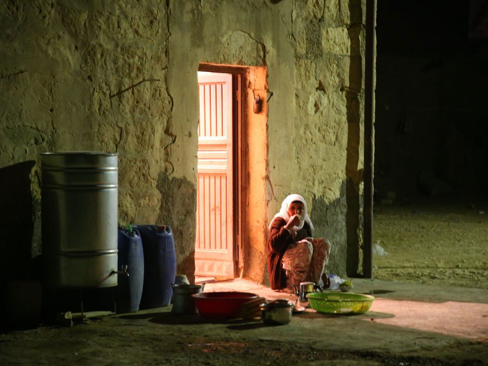 A woman in the village of Alizar, on the border between Turkey and Syria, keeps guard during the night, fearful of mortar attacks from Isis