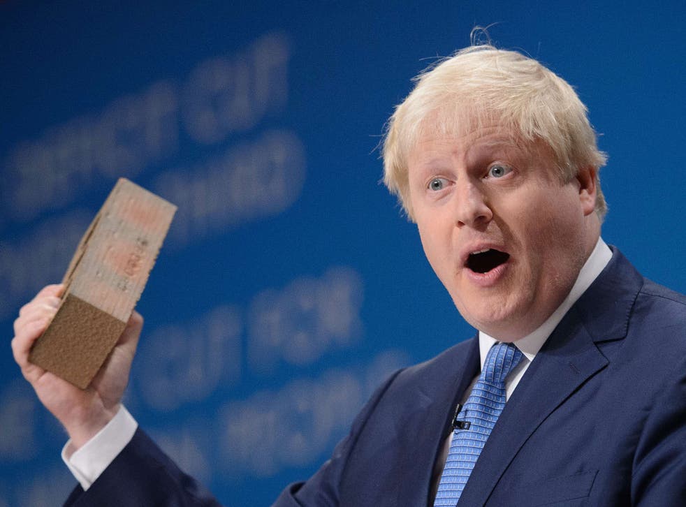 Mayor of London Boris Johnson holds a brick as he addresses delegates on the third day of the annual British Conservative Party conference in Birmingham
