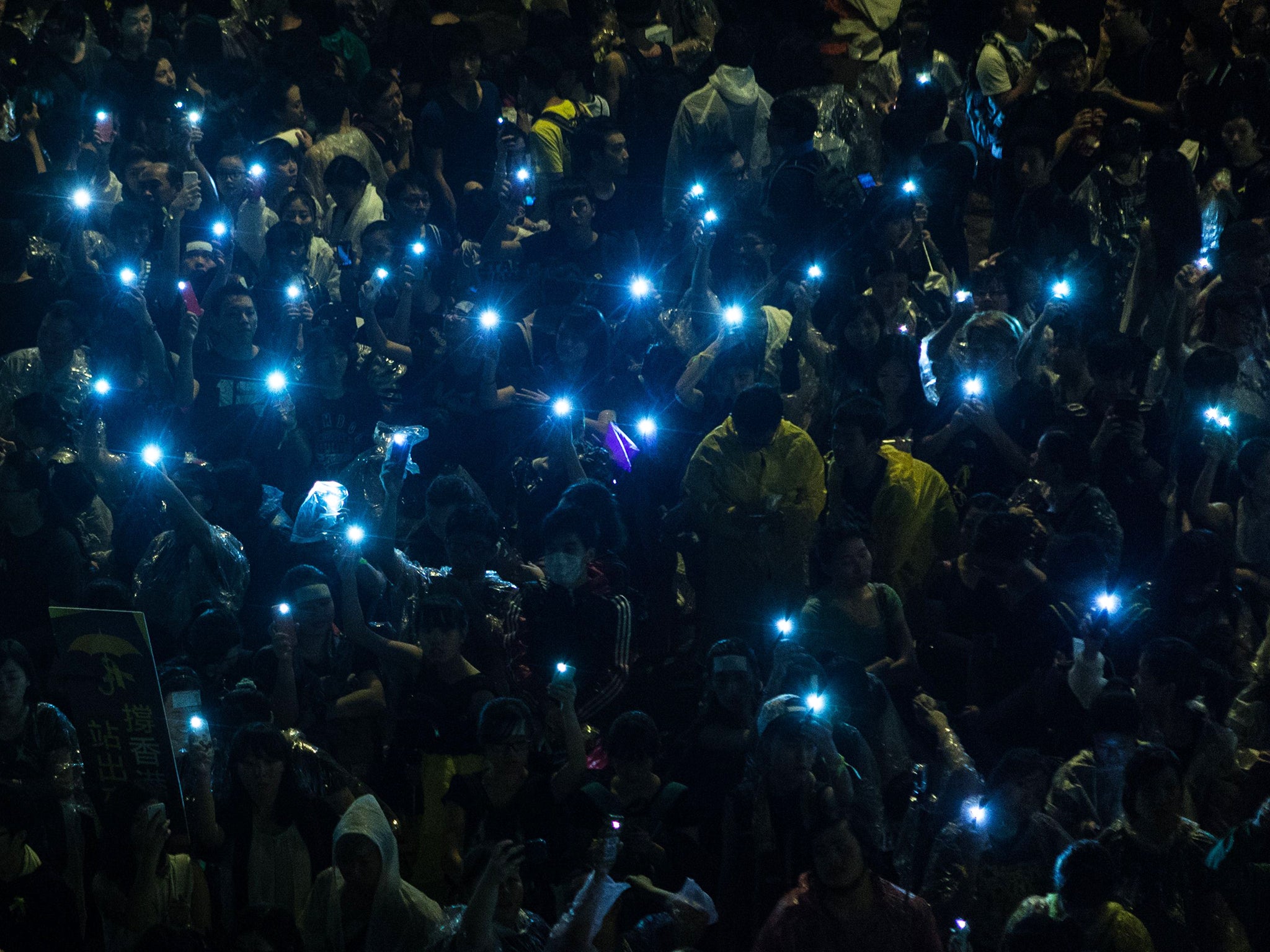 Pro-democracy protesters hold up their mobile phones after heavy rain in Hong Kong. Hong Kong has been plunged into the worst political crisis since its 1997 handover as pro-democracy activists take over the streets following China's refusal to grant citi