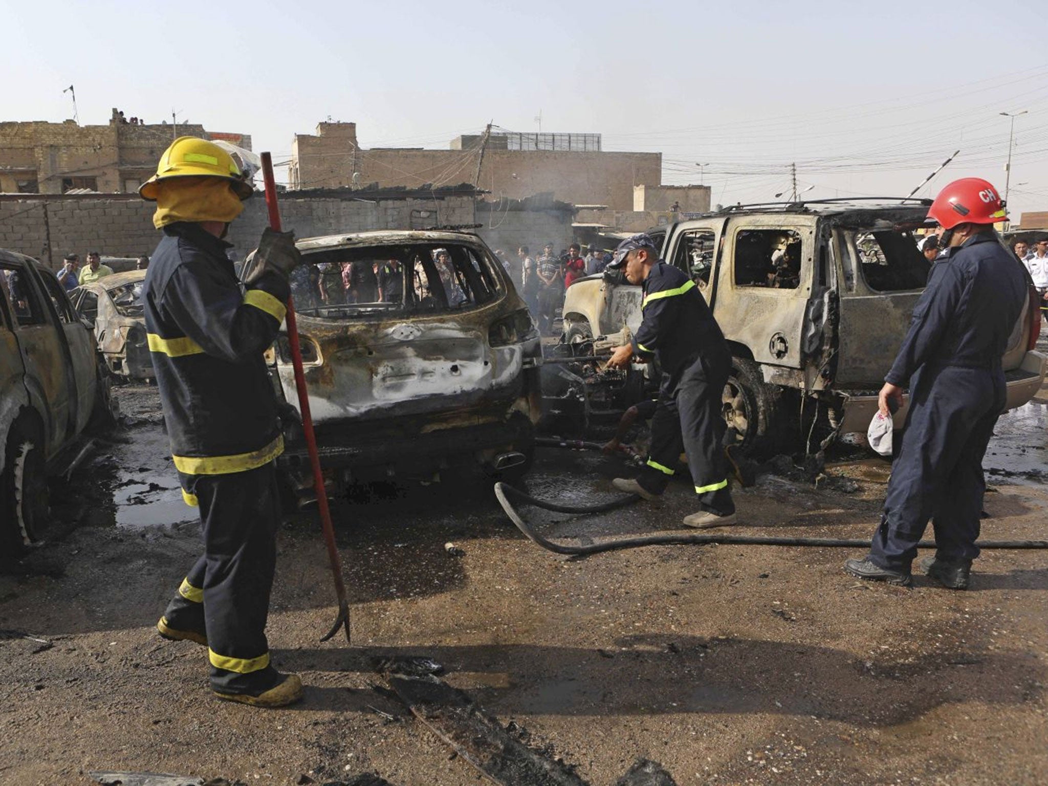 Iraqi firemen work at the scene of a car bomb explosion in the town of Ashar, in Basra