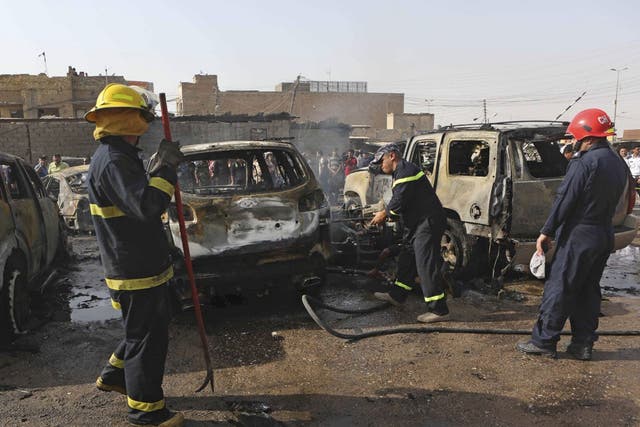 Iraqi firemen work at the scene of a car bomb explosion in the town of Ashar, in Basra