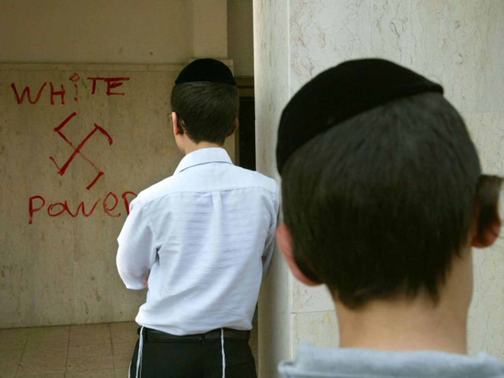 Destructive discourse: Jewish boys look at anti-Semitic graffiti sprayed on to the walls of the synagogue in March 2006, near Tel Aviv