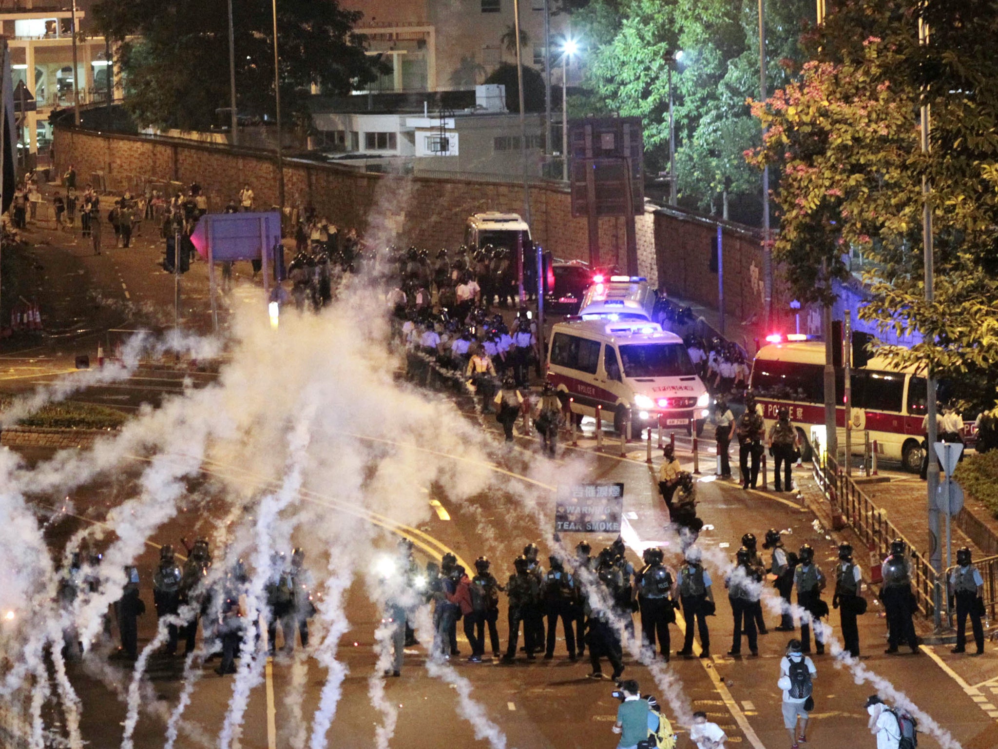 Riot police fire tear gas on student protesters occupying streets surrounding the government headquarters in Hong Kong