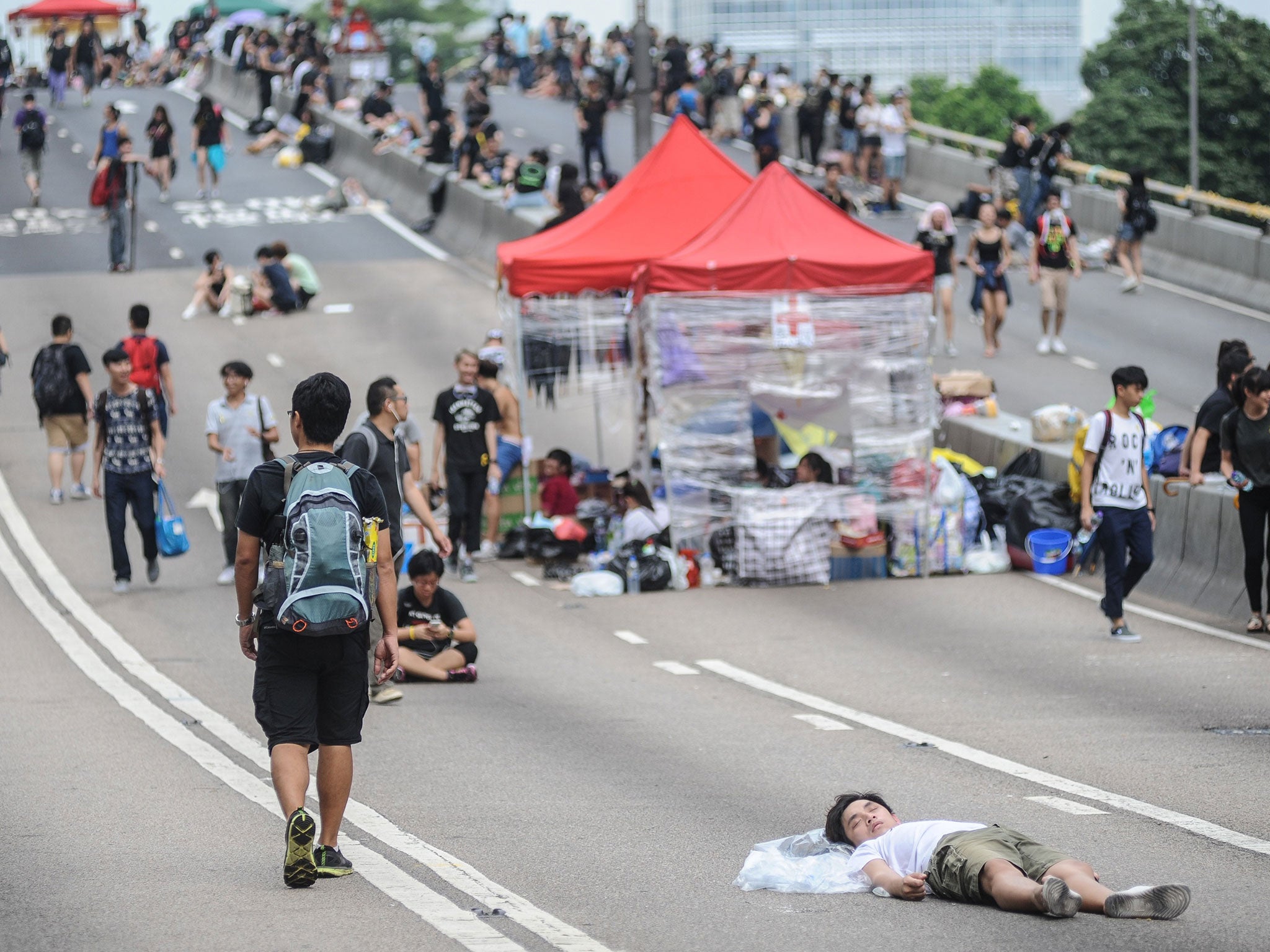 A pro-democracy demonstrator sleeps on the road outside the Government Complex in Hong Kong on October 2