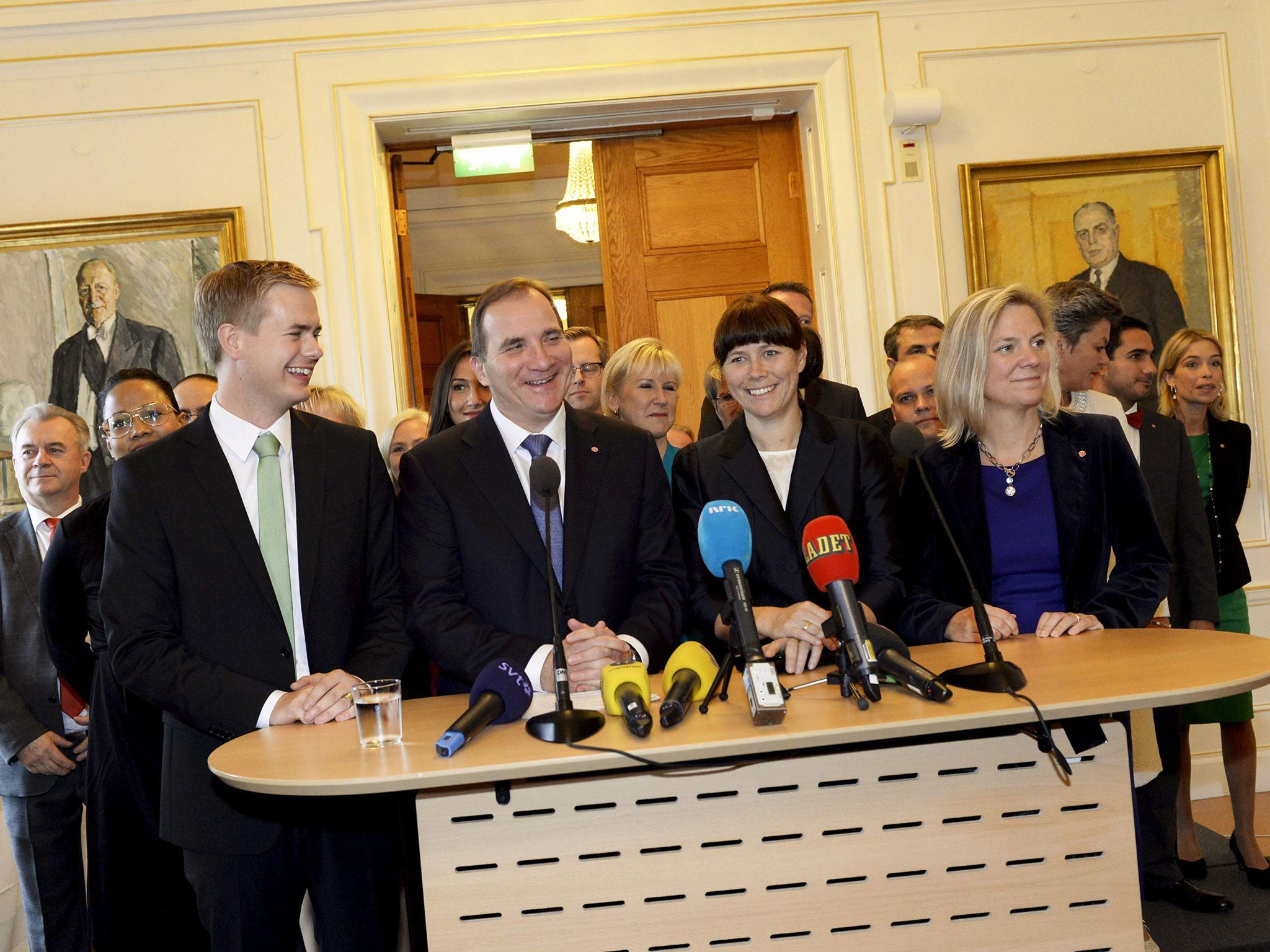 Swedish Prime Minister Stefan Lofven (front 2nd L) smiles as he stands with his new government during a news conference in Stockholm 3 October