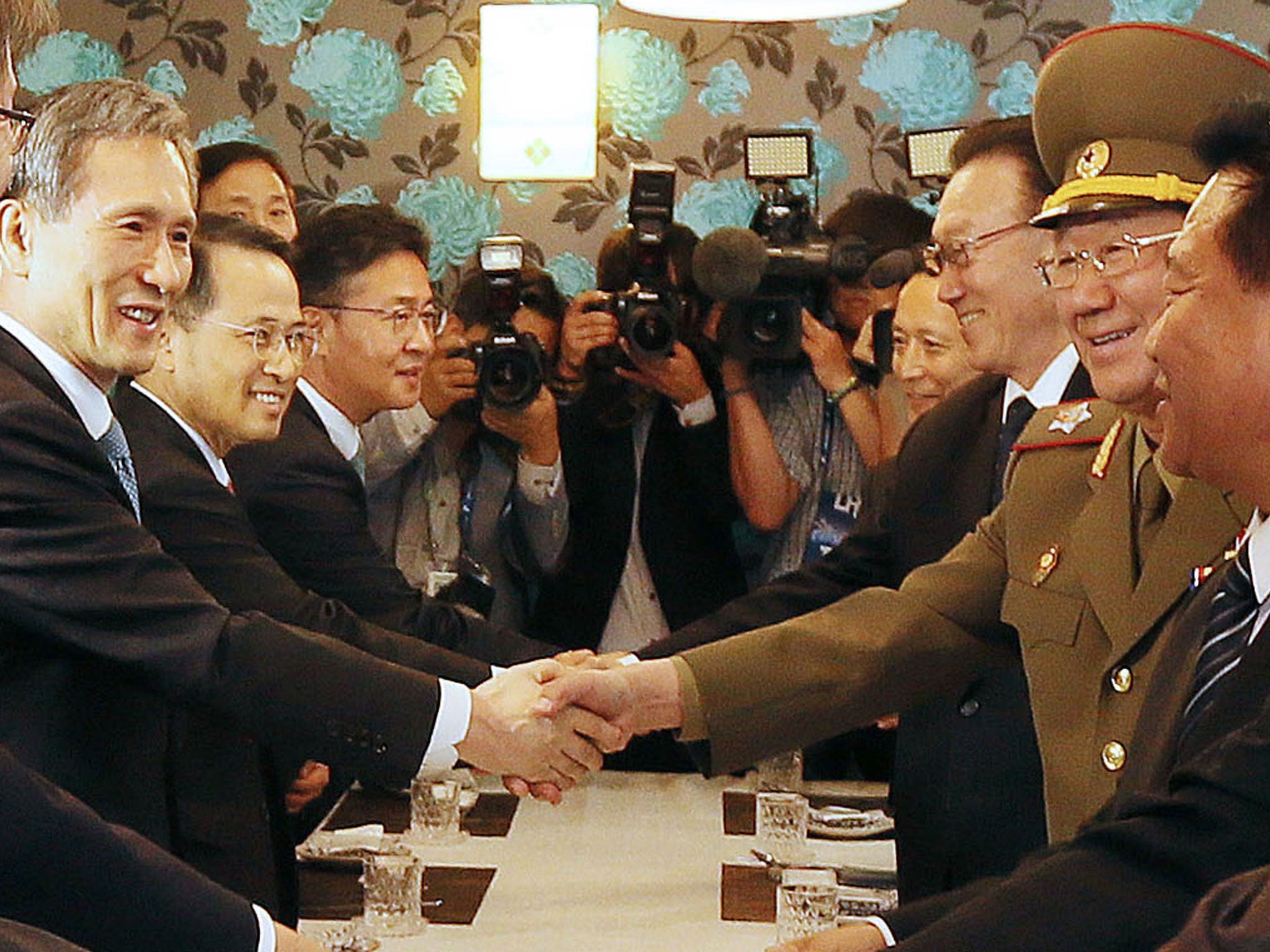 South Korea's national security advisor Kim Kwan-Jin (L) shakes hands with Hwang Pyong-So (2nd R), director of the military's General Political Bureau