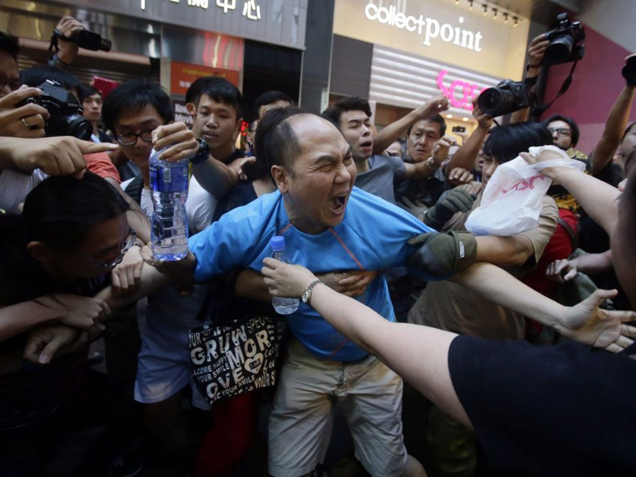 Demonstrators pull at a man protesting against their occupation of the Hong Kong streets on Saturday