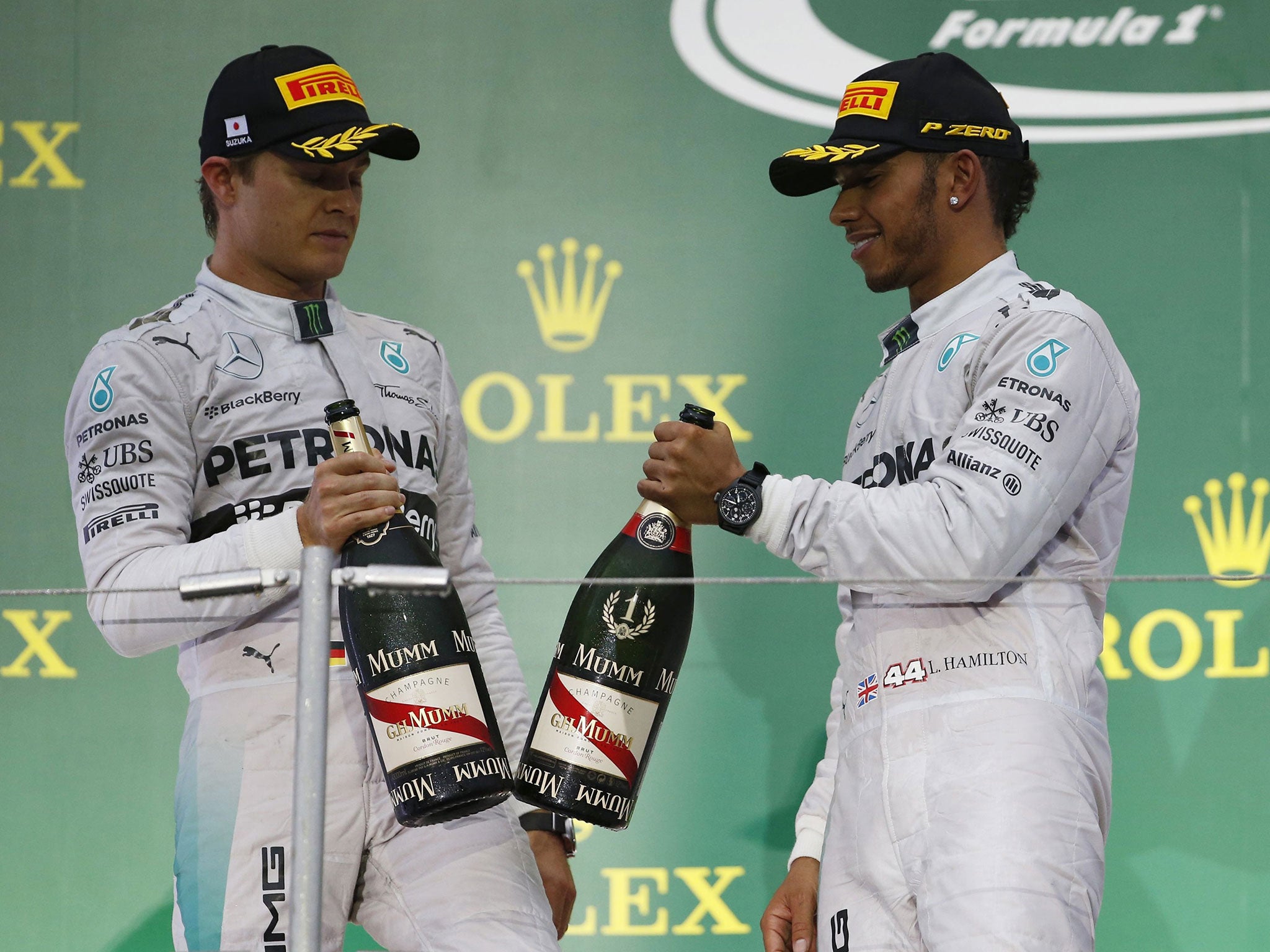 Mercedes Formula One driver Lewis Hamilton (R) of Britain celebrates with Mercedes Formula One driver Nico Rosberg of Germany after Hamilton won the Japanese Grand Prix