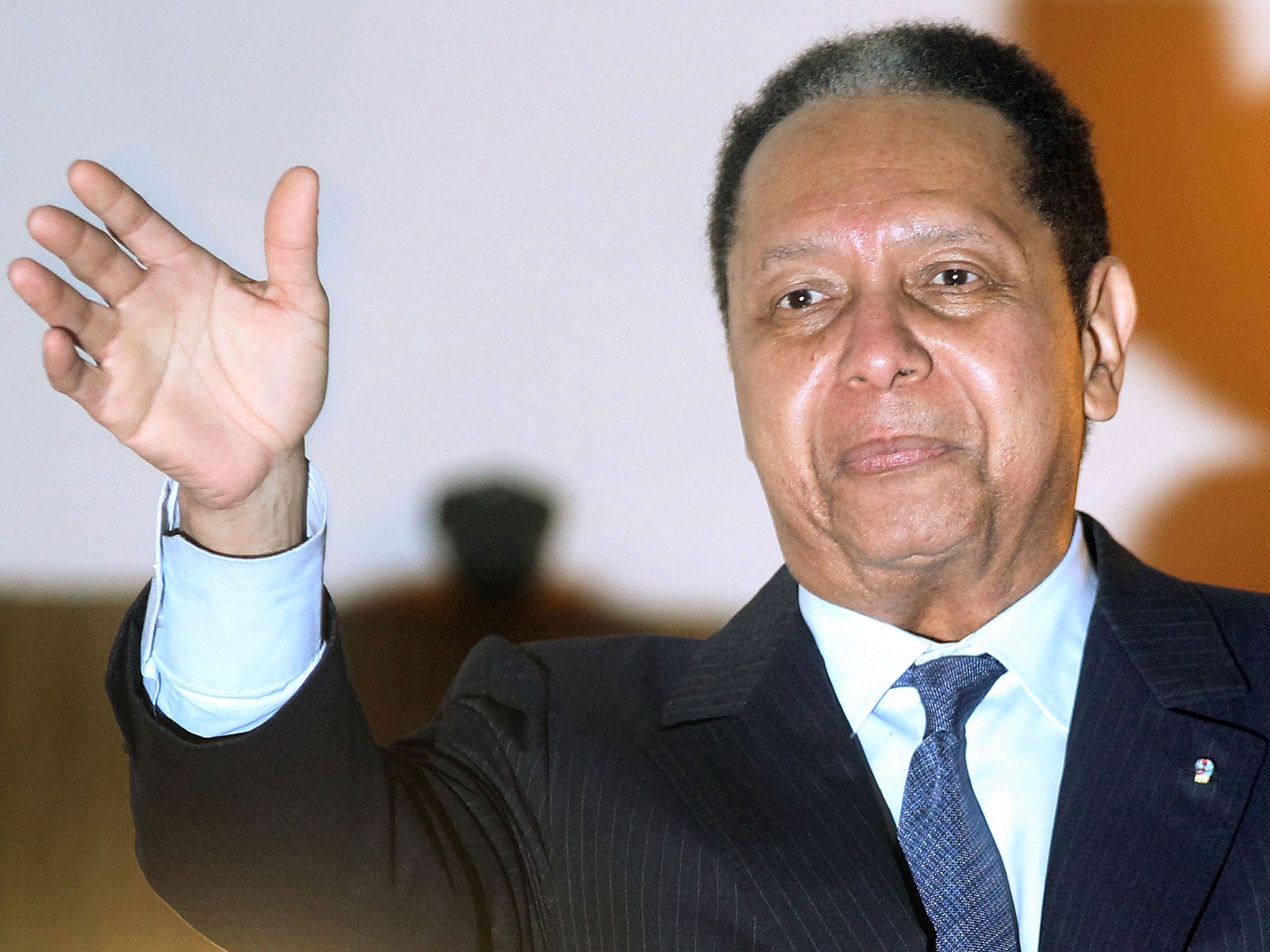 Former Haitian president Jean-Claude Duvalier waves to supporters in January 2011 upon his return to the island