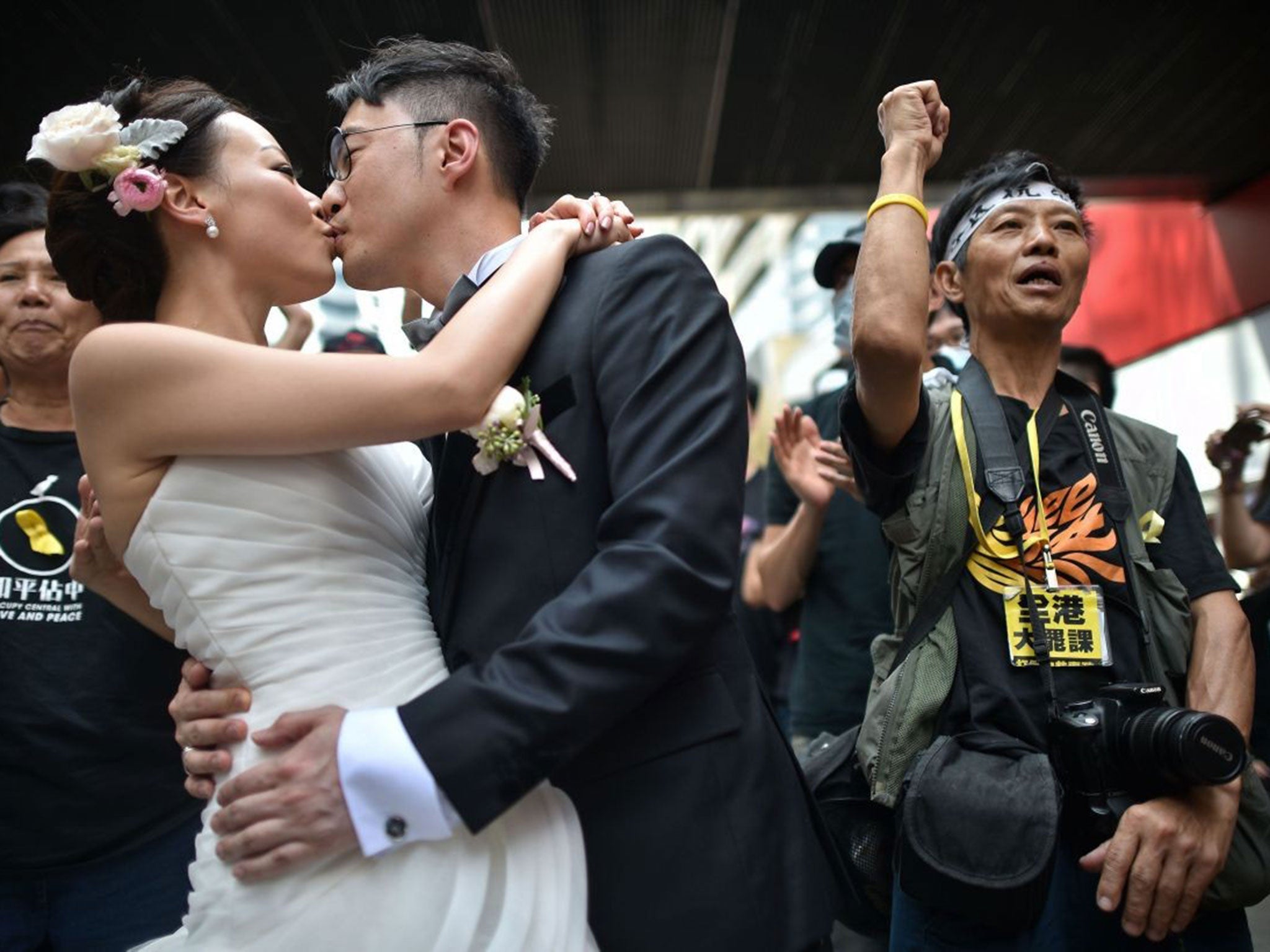 A couple take wedding photographs in front of pro-democracy protesters in Hong Kong on 1 October