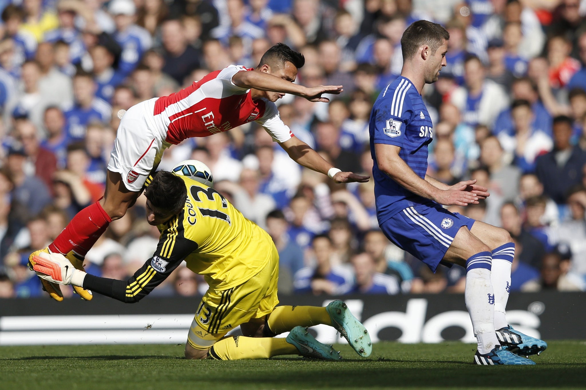Arsenal's Chilean striker Alexis Sanchez (L) collides with Chelsea's Belgian goalkeeper Thibaut Courtois