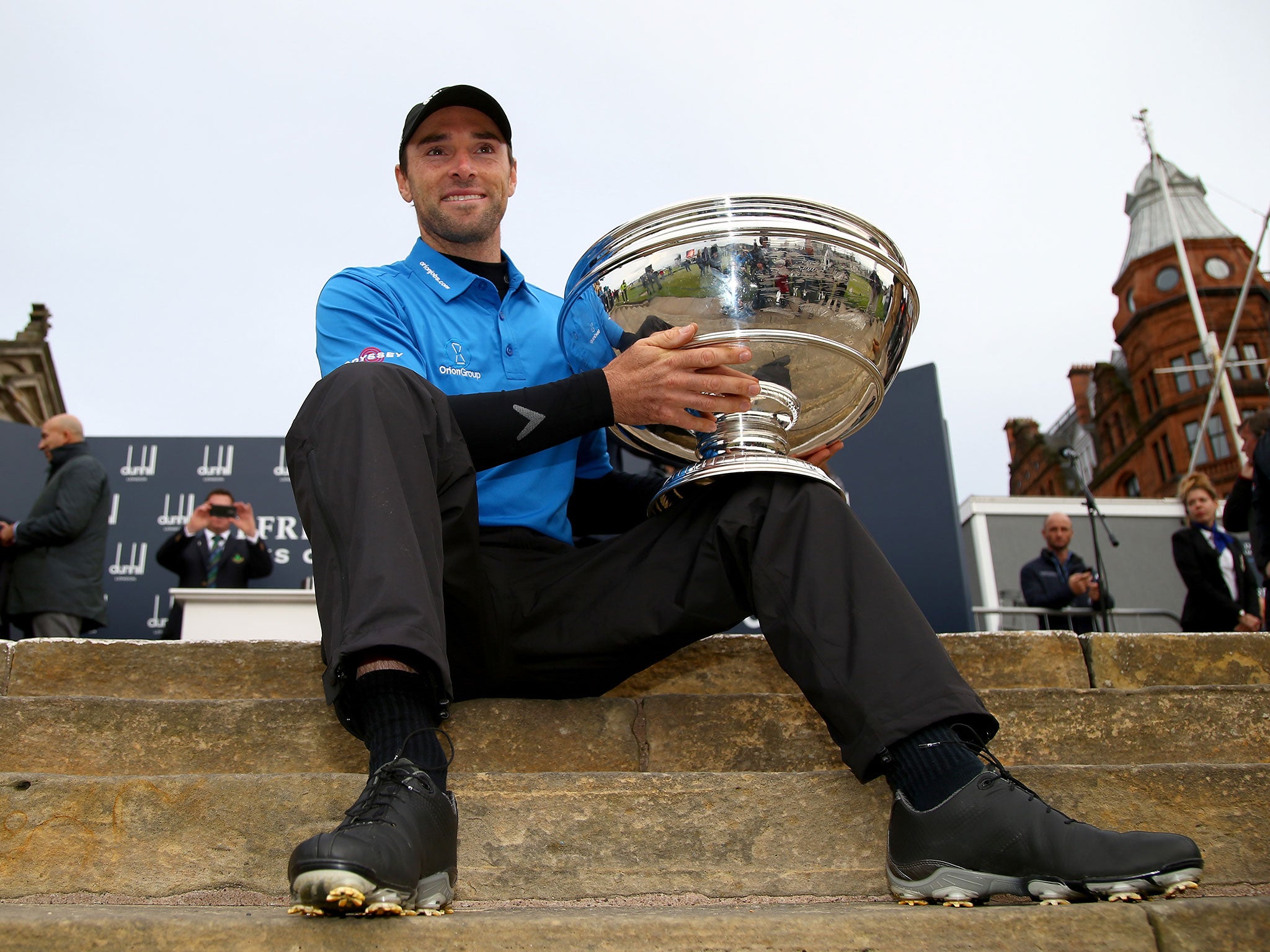 Oliver Wilson of England holds the trophy aloft after victory in the 2014 Alfred Dunhill Links Championship