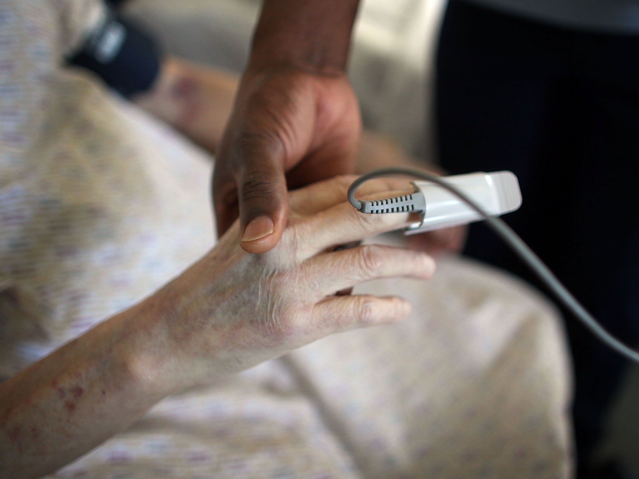 An elderly woman receives treatment in an NHS hospital