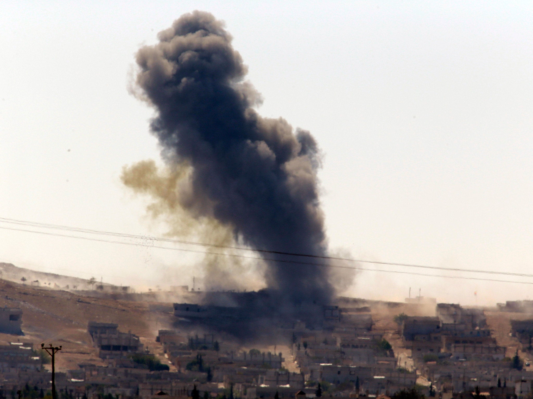 Smoke rises after a shell lands in Kobani in Syria as fighting intensifies between Syrian Kurds and Isis militants