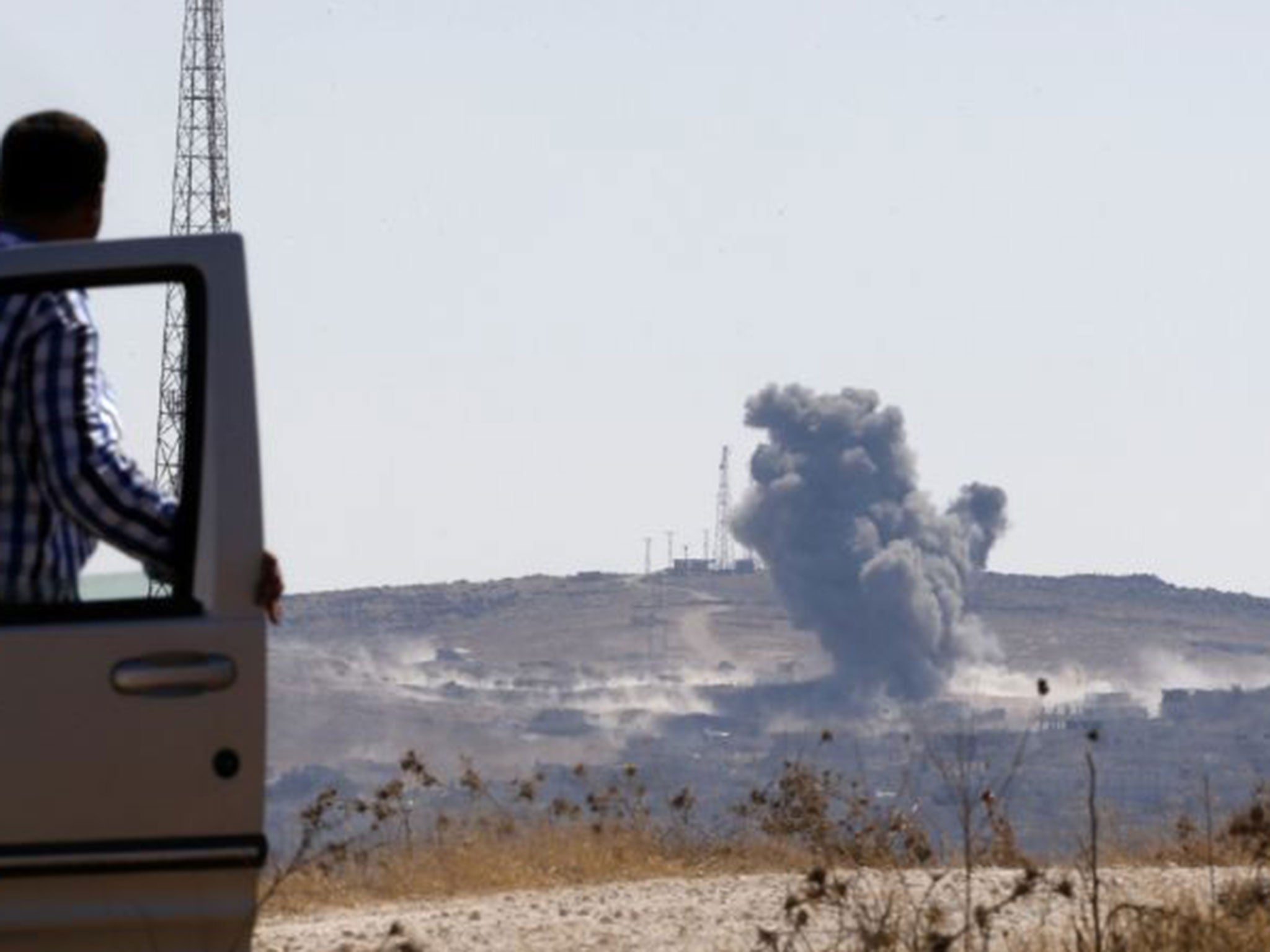 Smoke rises from the Syrian town of Kobani, seen from near the Mursitpinar border crossing on the Turkish-Syrian border on 6  October 2014
