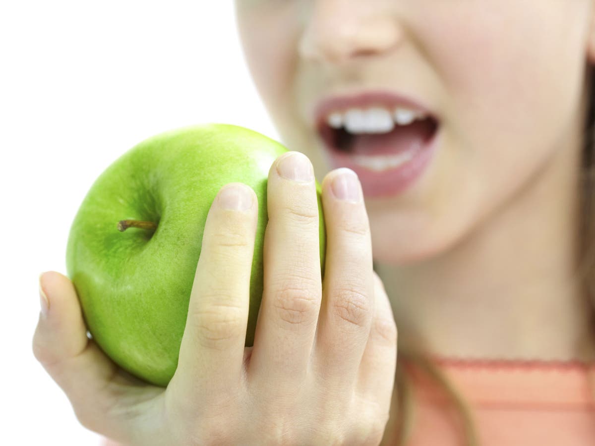 She s eating an apple. Откушенное яблоко. Зеленое яблоко в женской руке. Девушка откусывает яблоко. Откушенное зеленое яблоко в руке.