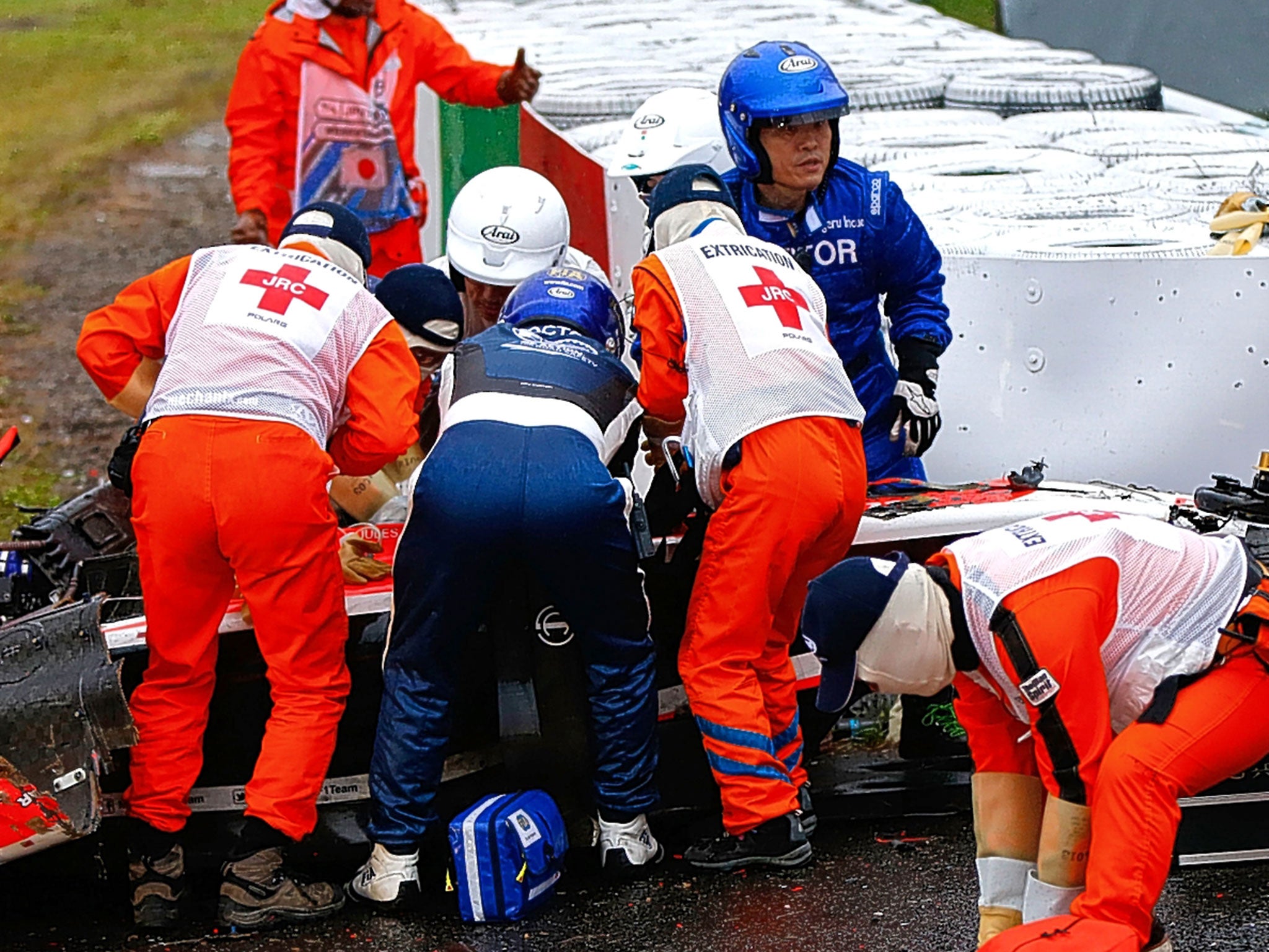 Bianchi is tended to in his car following the crash at Suzuka on Sunday