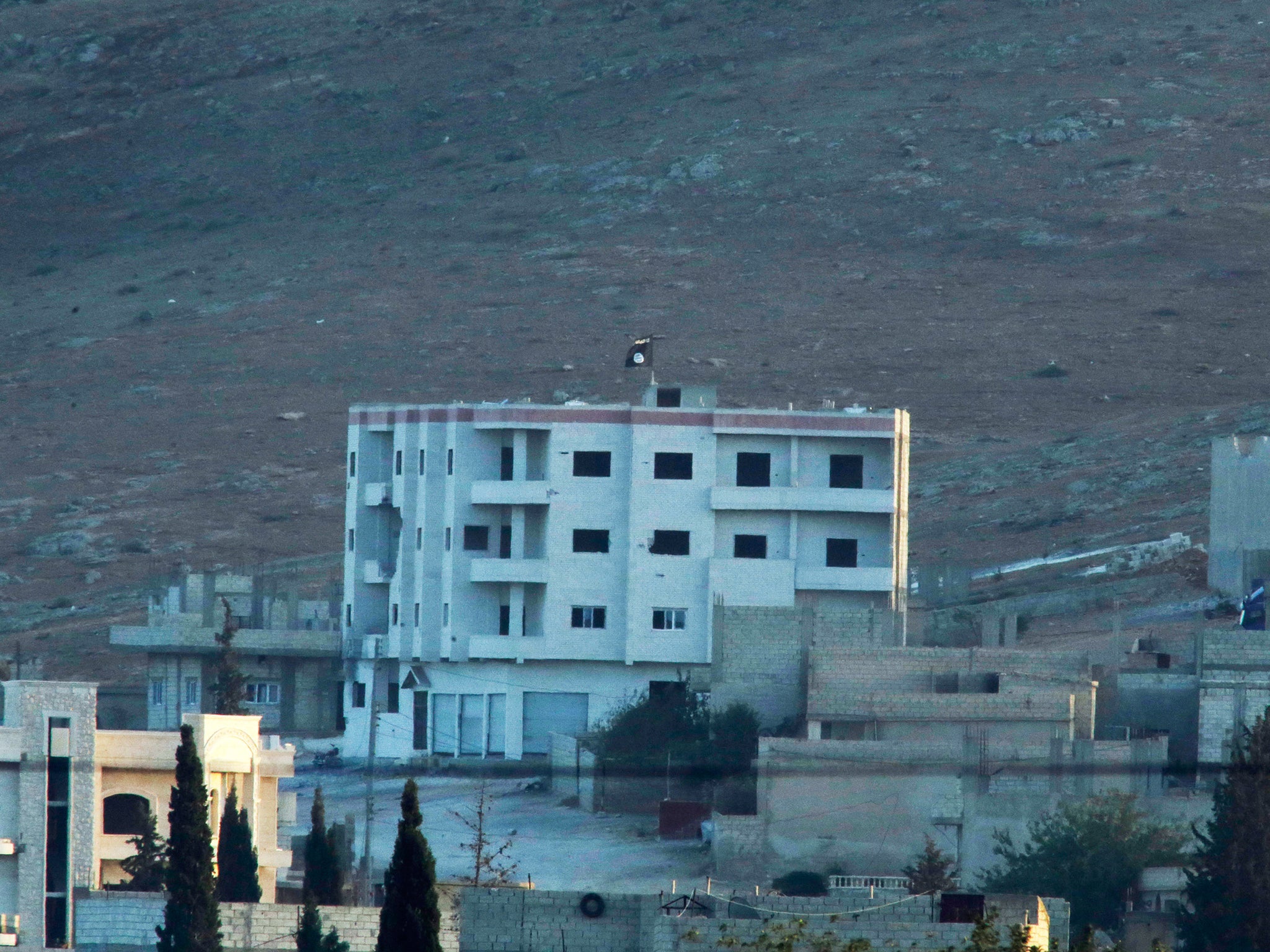 The Isis flag on top of a building at the eastern side of Kobani