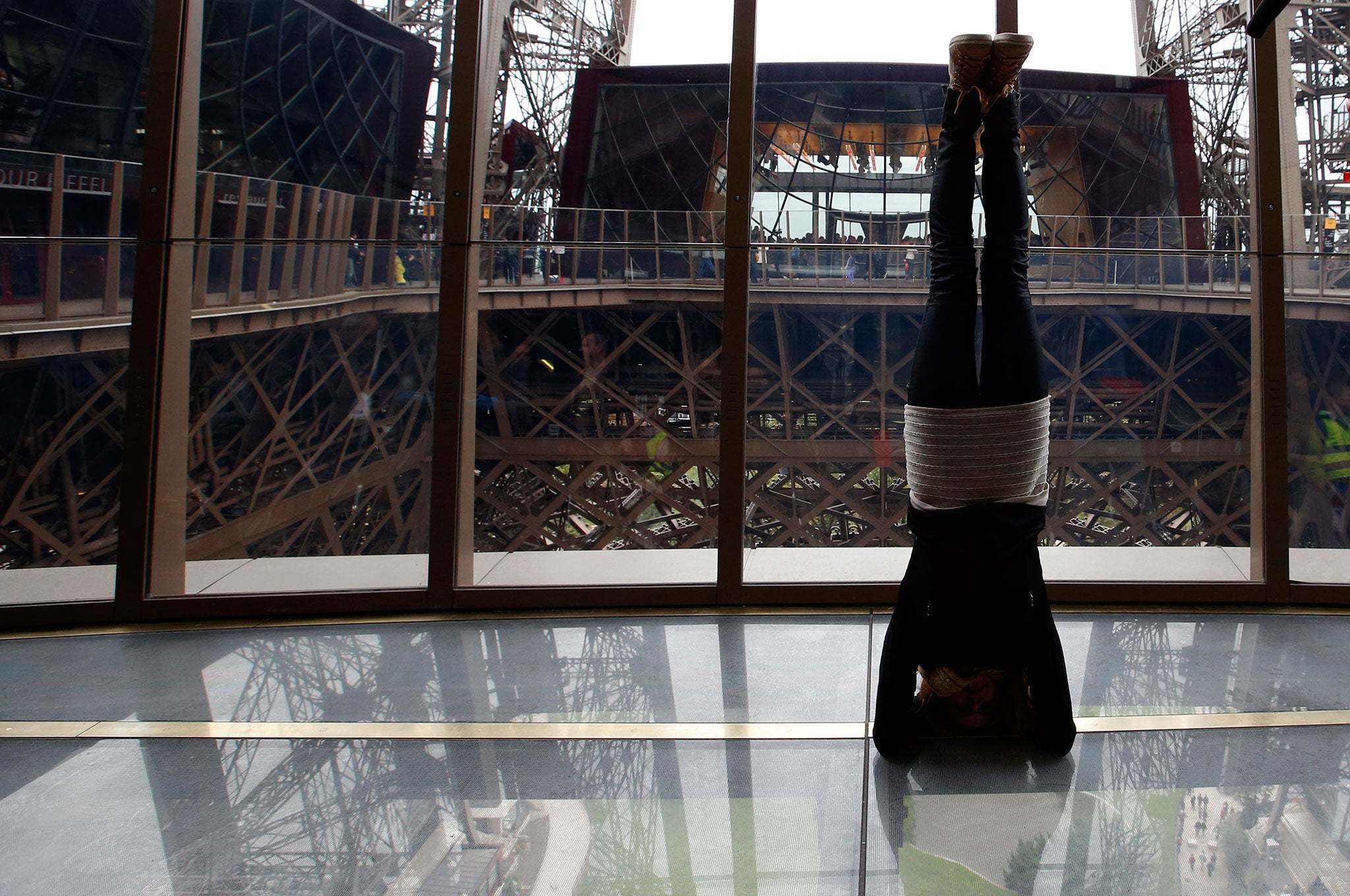 Visitor Ewa Jarlinska, 32 from Poland, performs a headstand, on the new glass floor at The Eiffel Tower