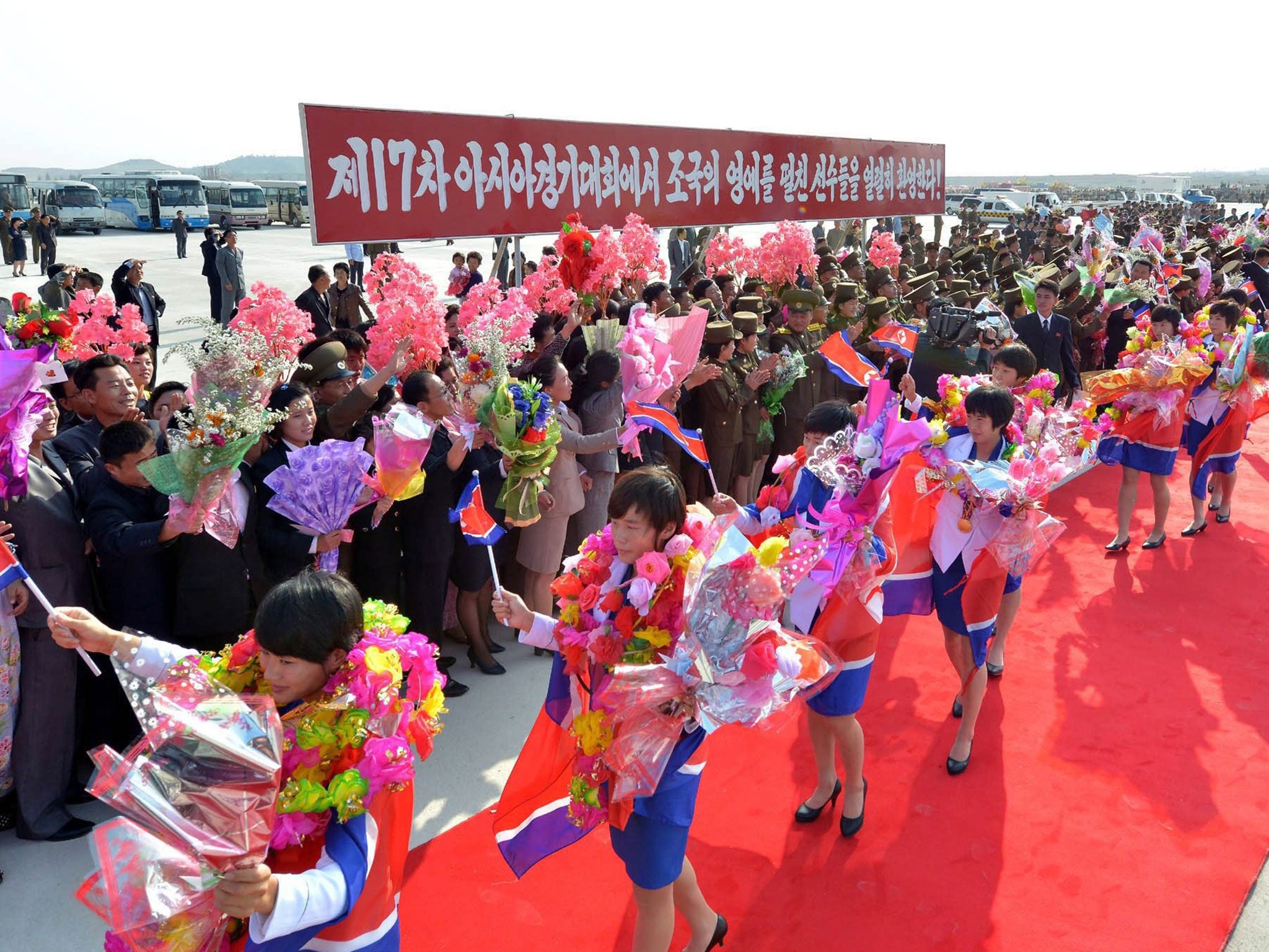 A picture released by the North Korean Central News Agency (KCNA) on 06 October 2014 shows North Korea's Asian Games athletes welcomed by officials and citizens after arriving at the airport in Pyongyang
