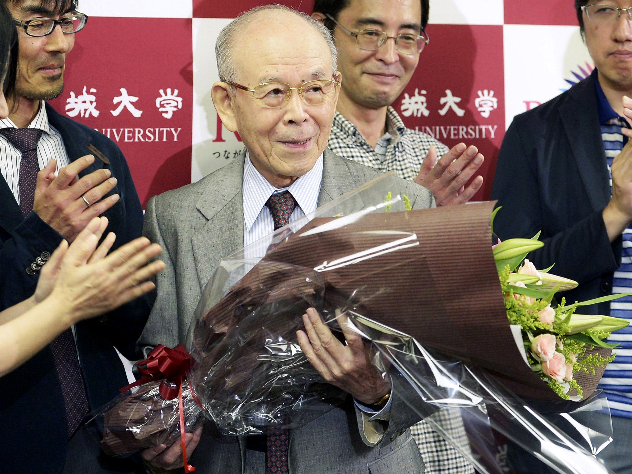 Meijo University Prof. Isamu Akasaki, holds a flower bouquet at a news conference after winning the Nobel Prize in physics at the university in Nagoya, Japan