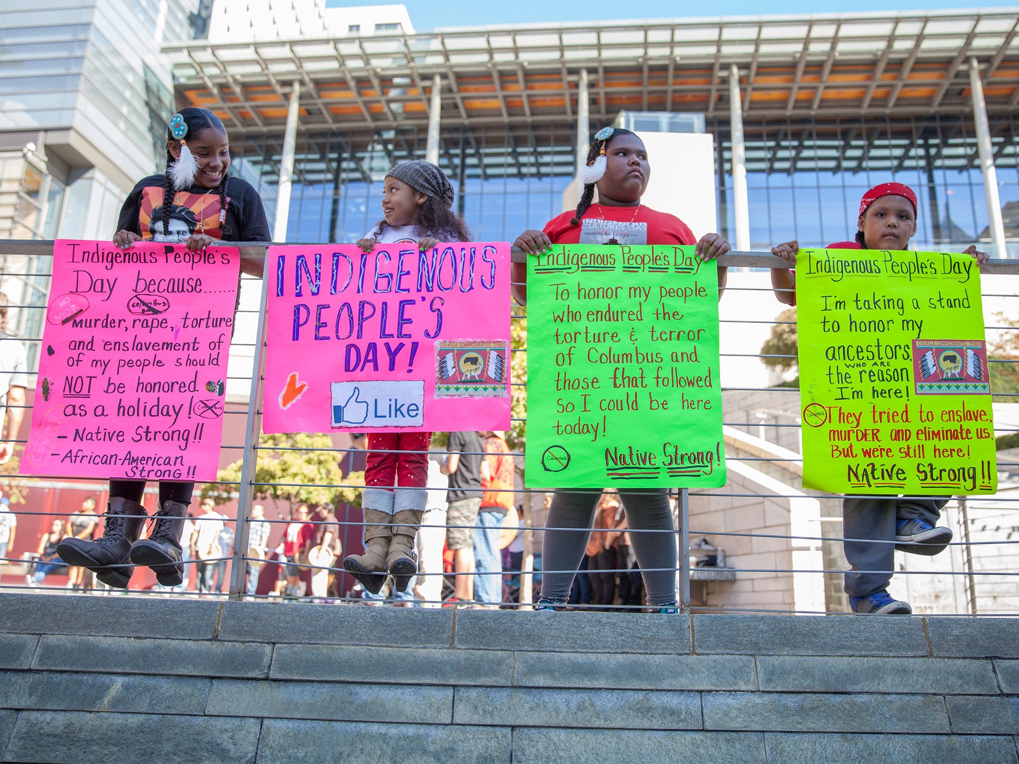 Children hold signs in front of Seattle's City Hall before the city council's historic vote to rename Columbus Day as Indigenous People's Day
